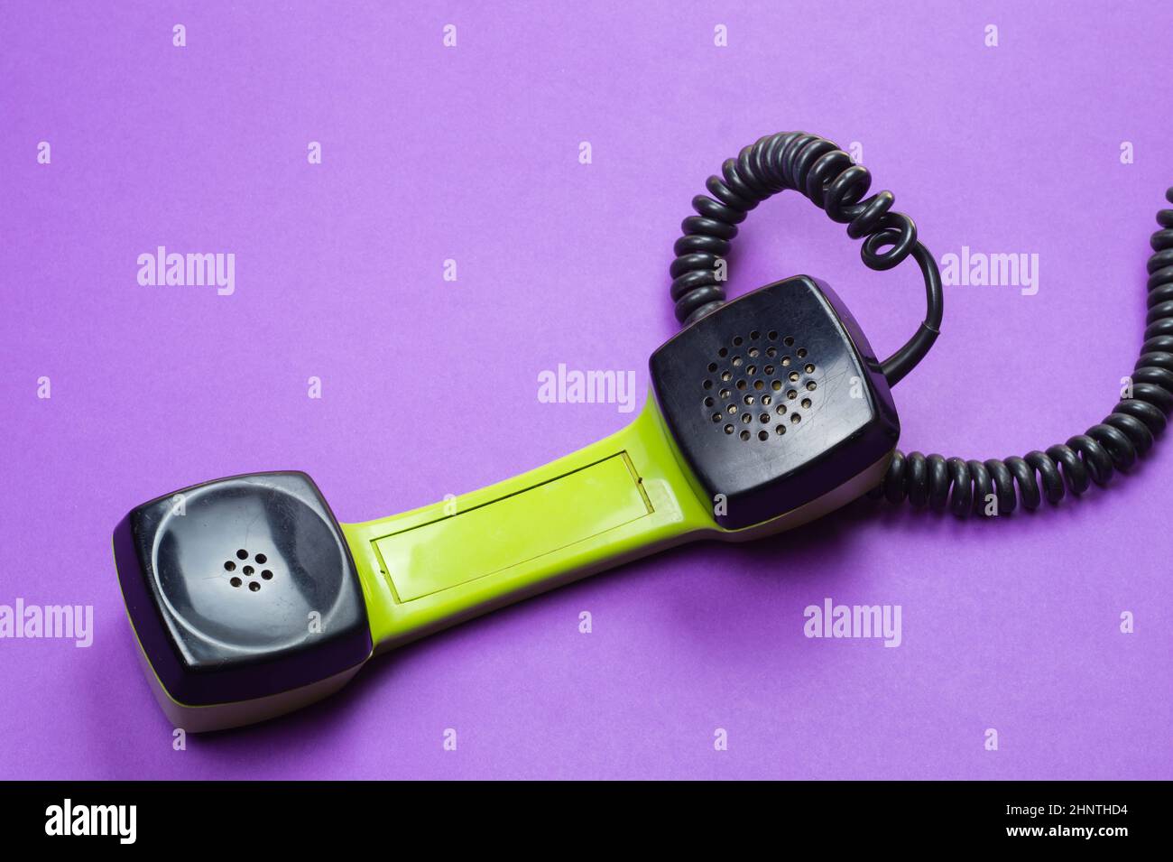 Telephone handset. phone receiver on purple background. old