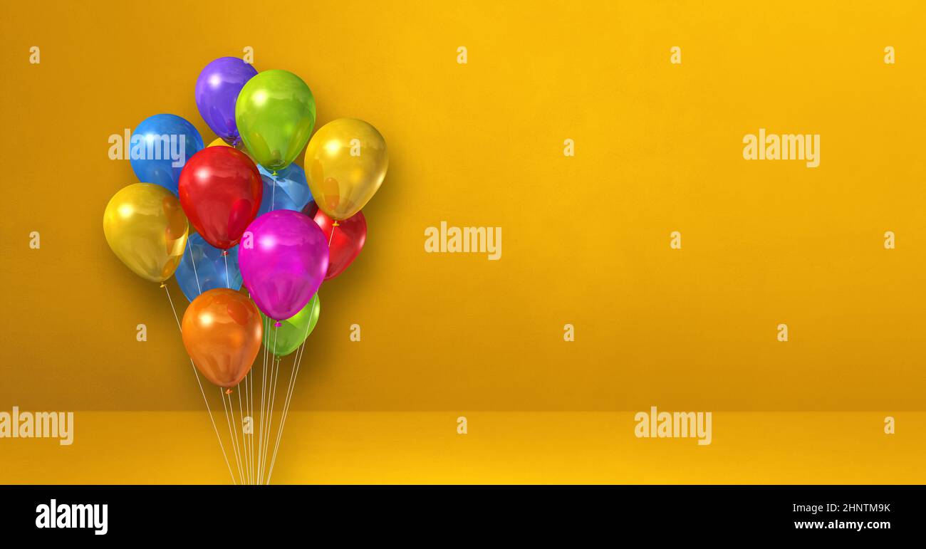 Colorful balloons bunch on a yellow wall background. Horizontal banner ...
