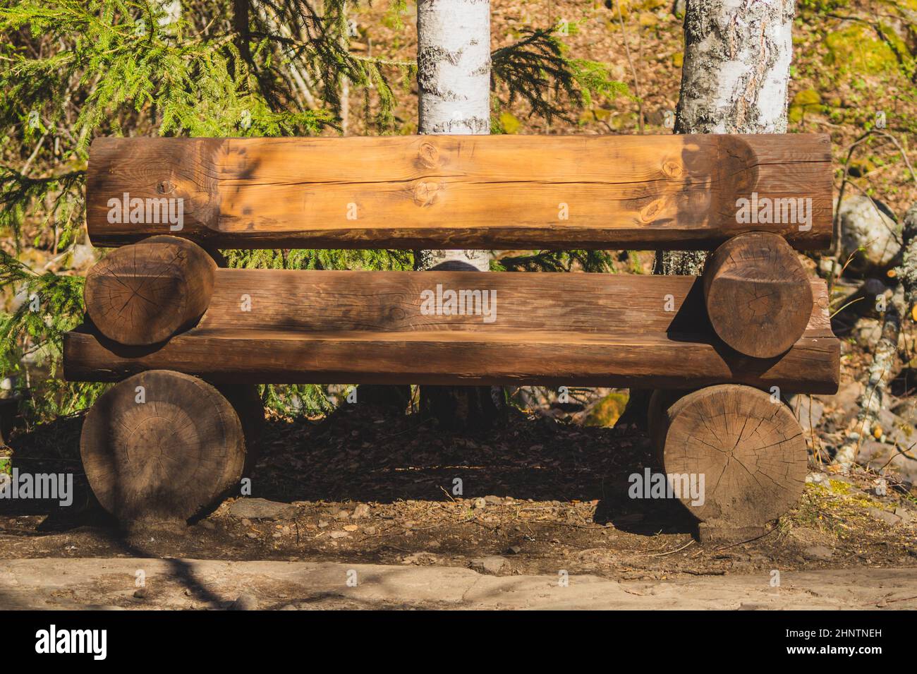 Wooden log bench in the forest. park decor Stock Photo - Alamy