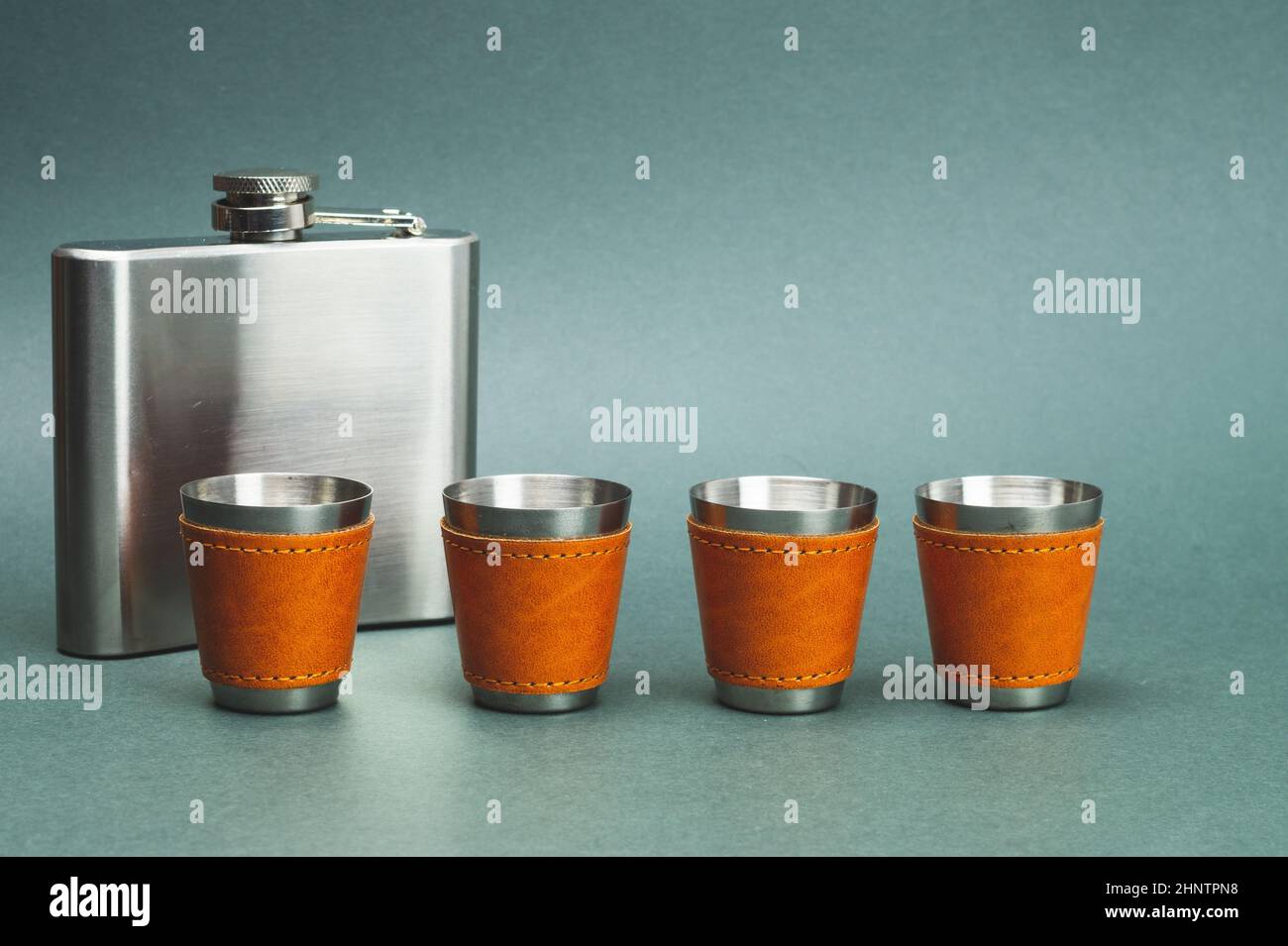 Metallic shot glasses in a row. metal flask. travel shot glass for