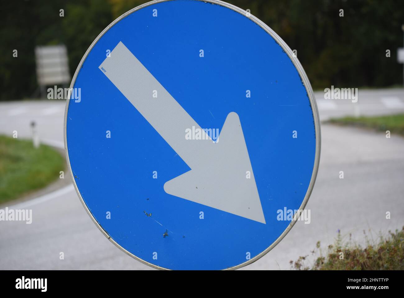 Direction sign with arrow showing the way in road traffic Stock Photo