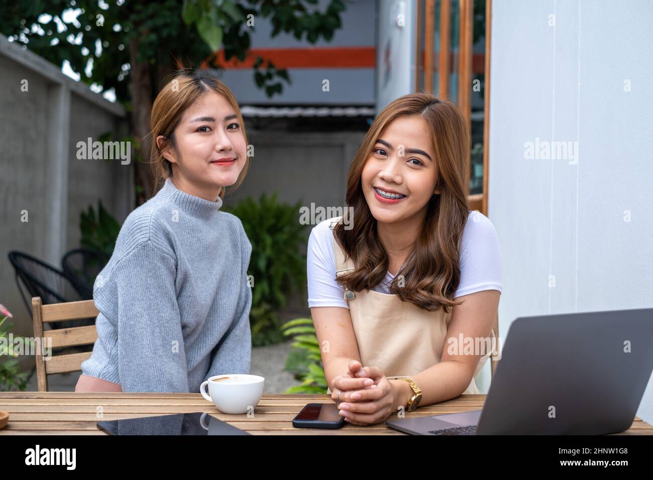 Friends Teenager Buddies Concept. Asian teen meeting at cafe and looking for friends coming. Stock Photo