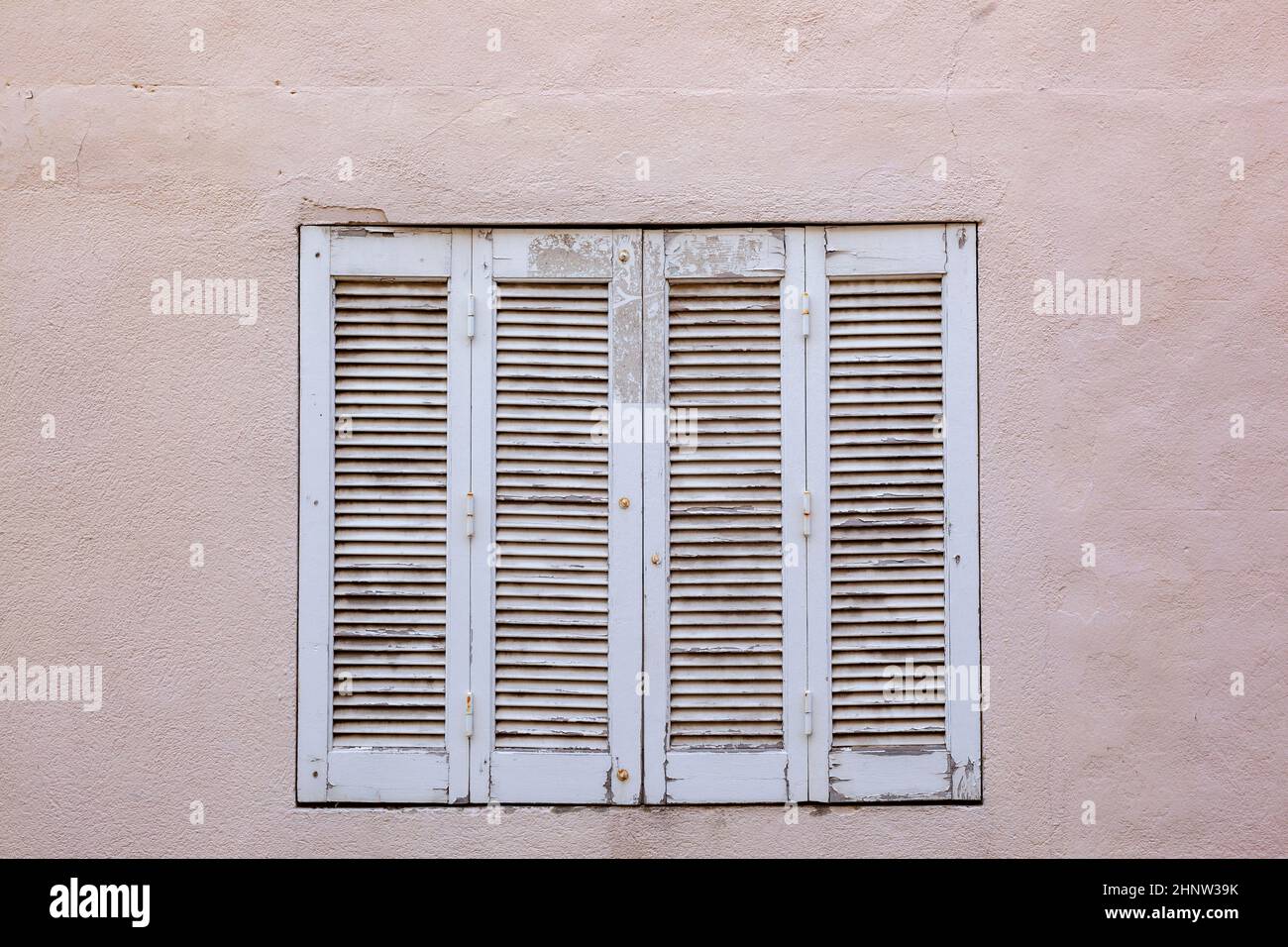 old house with wooden window shutter and peeling paint as background ...