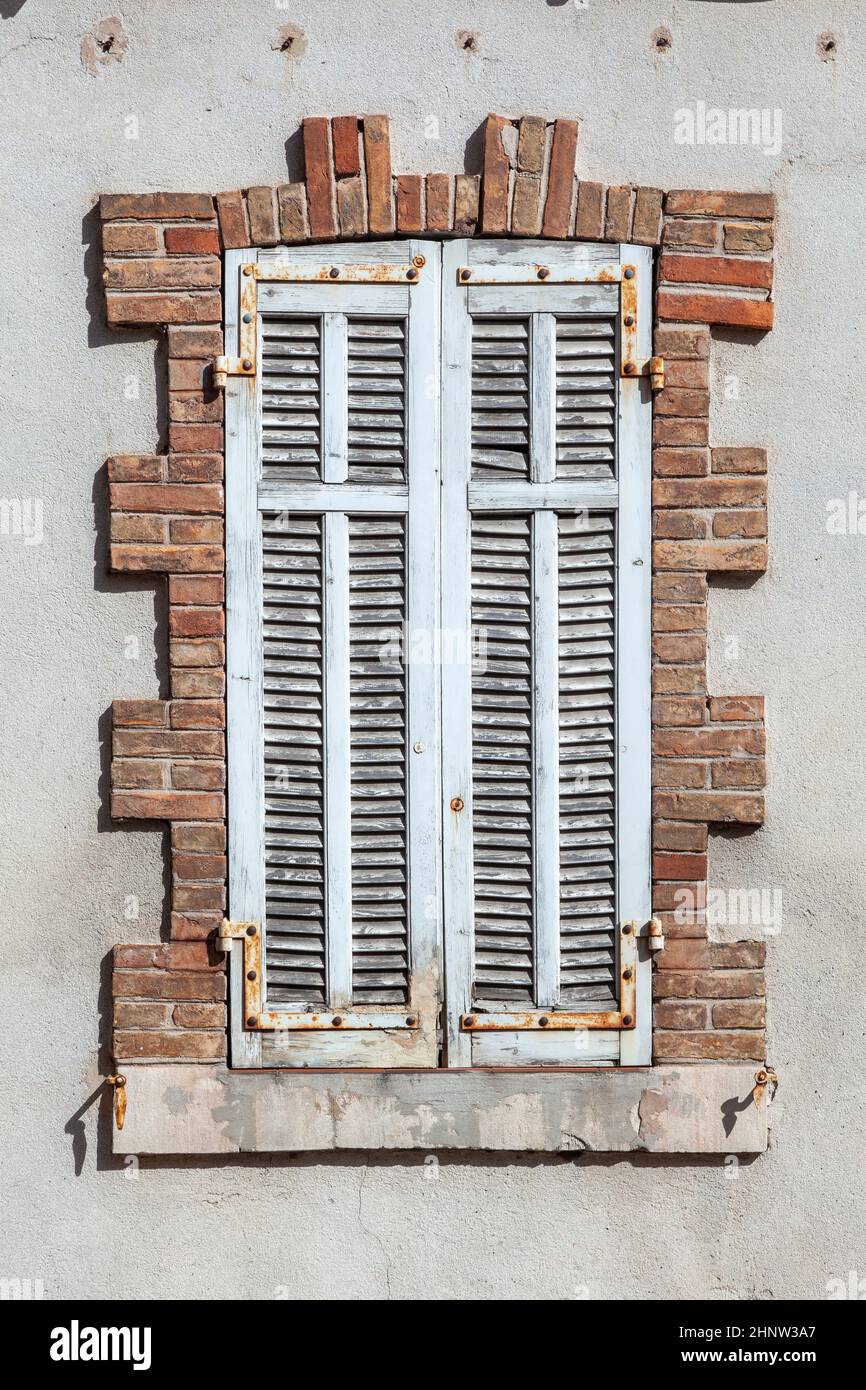 old house with wooden window shutter and peeling paint as background ...