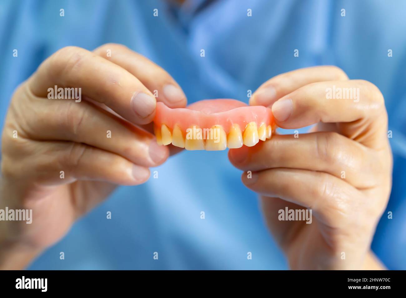 Asian senior or elderly old woman patient holding to use denture in