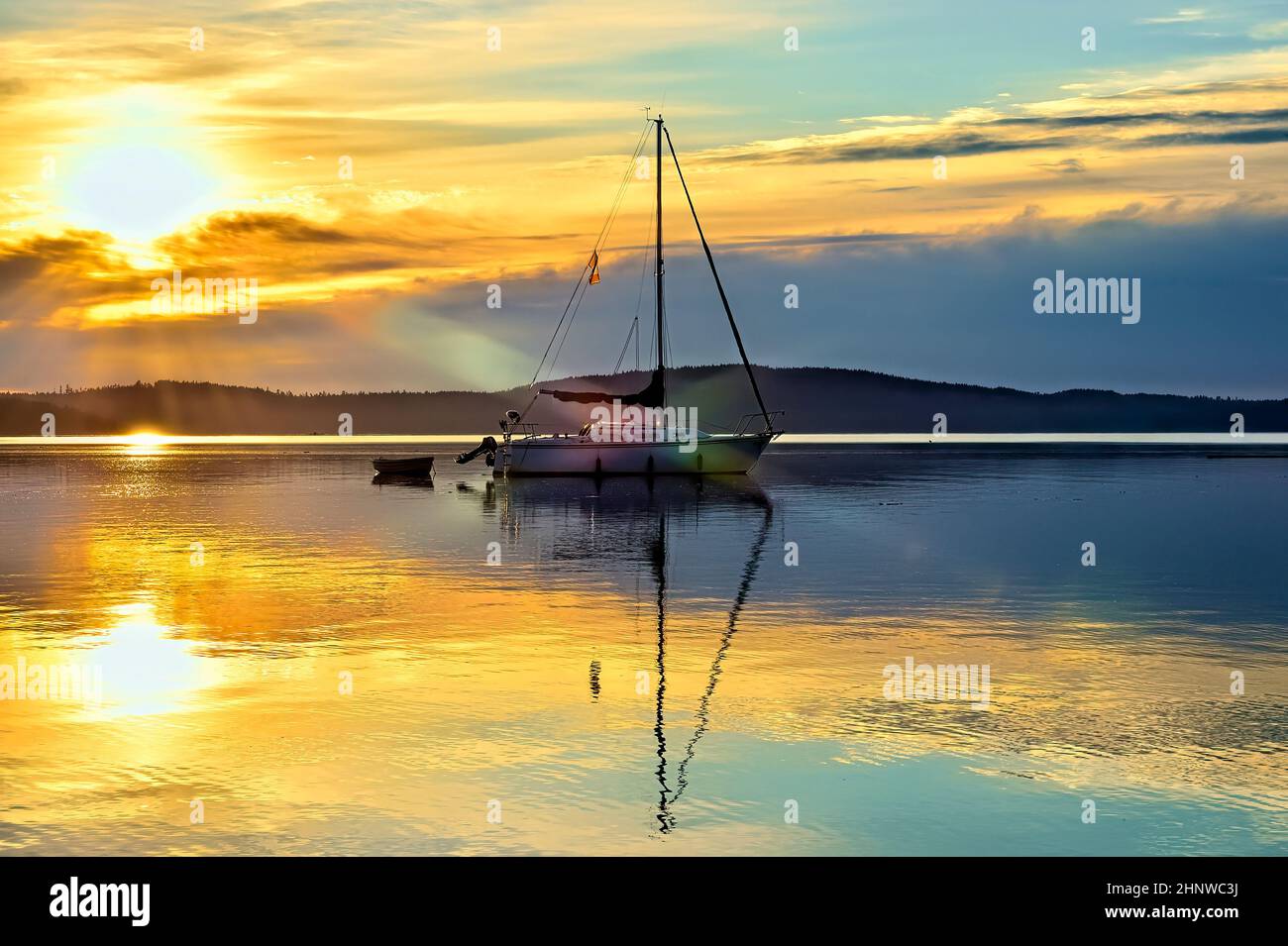 A sailboat moored in the early morning sunrise on the coast of Vancouver Island British Columbia Canada Stock Photo