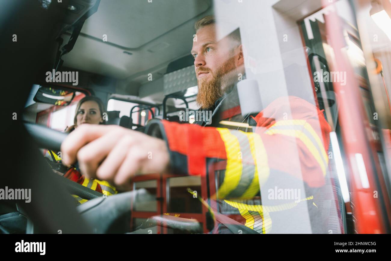 Driver of a fire truck in action on the steering wheel Stock Photo