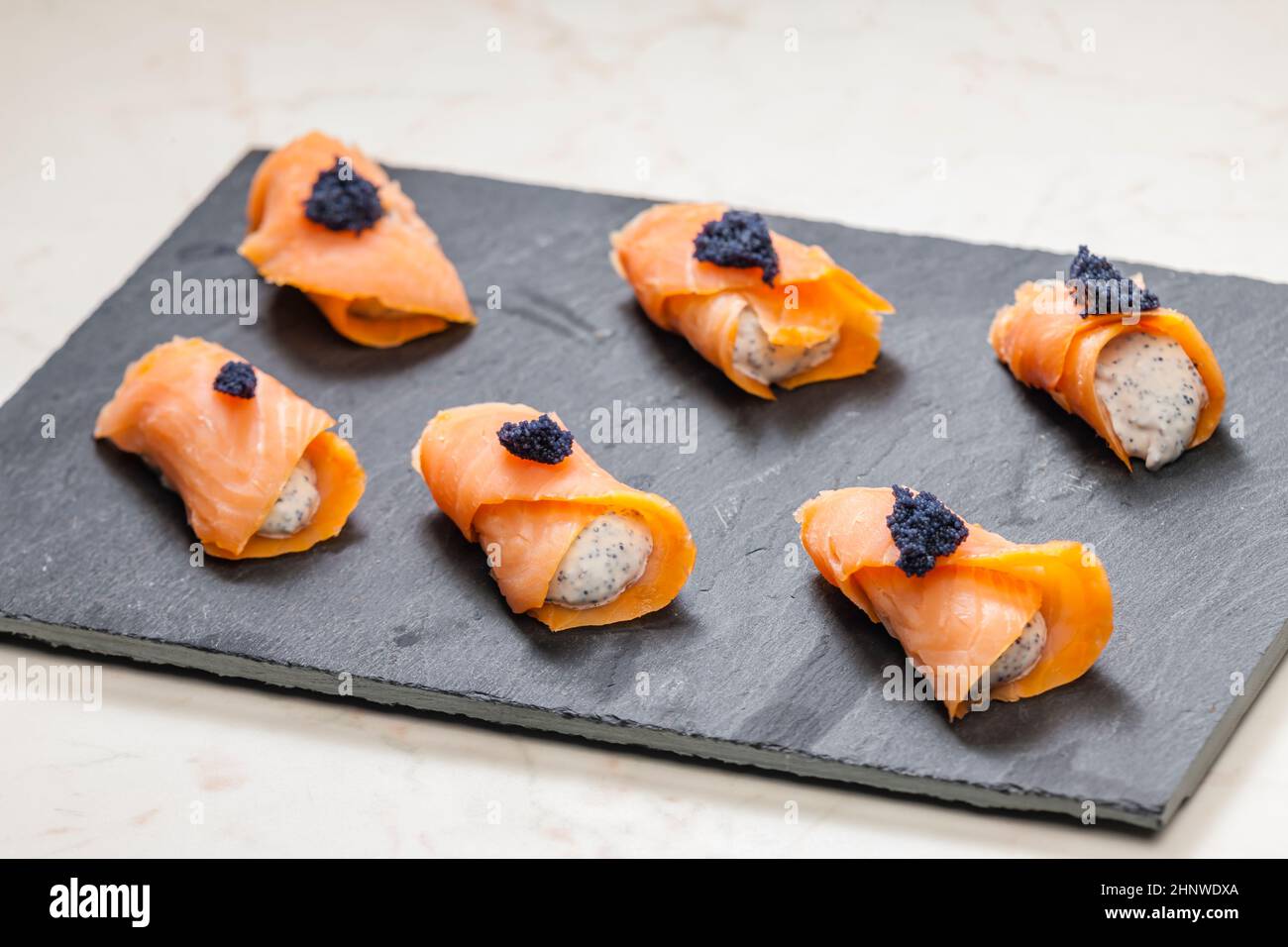 smoked salmon rolls filled with cream cheese and black caviar Stock Photo
