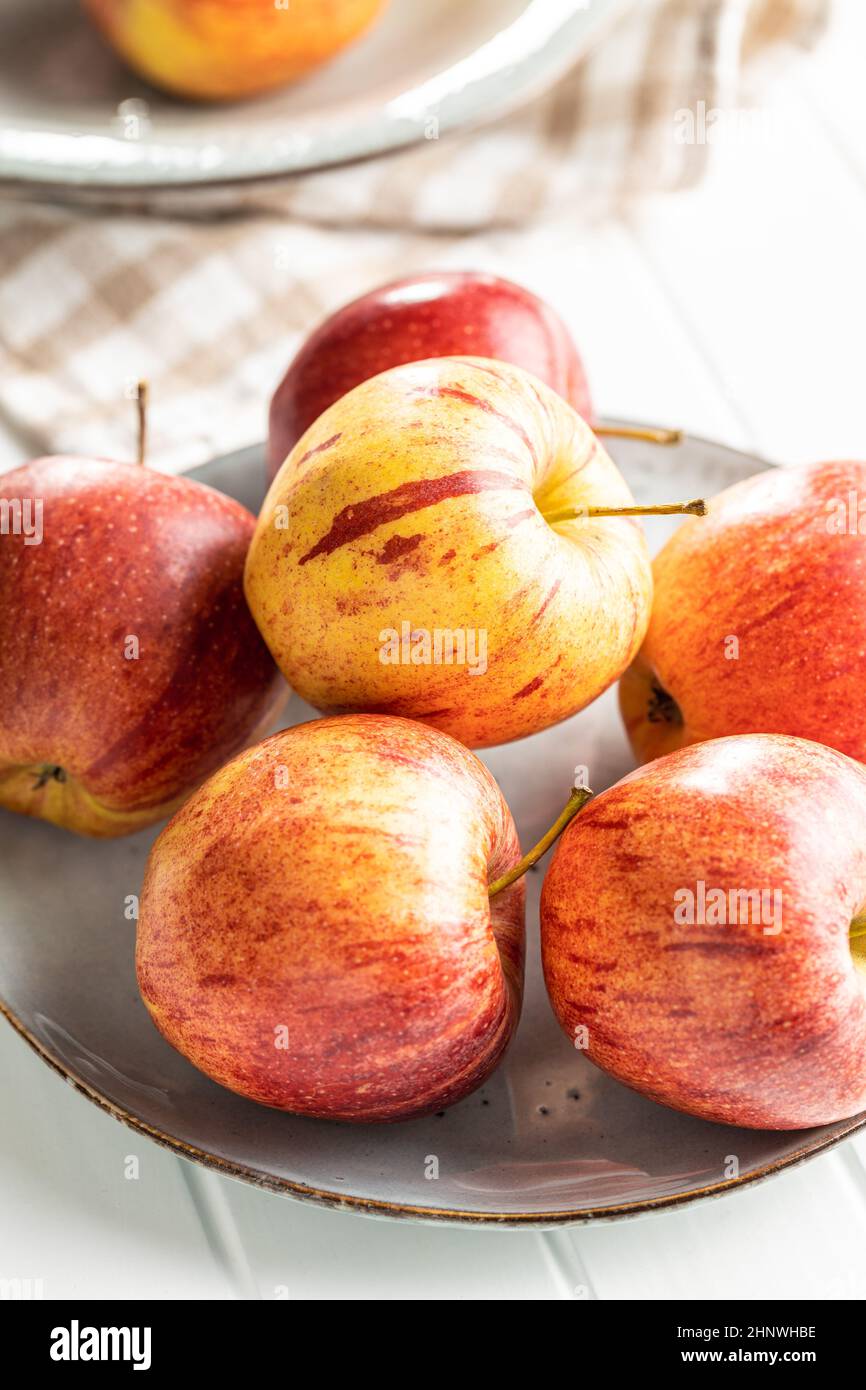 Fresh autumn apples on plate on white table. Stock Photo