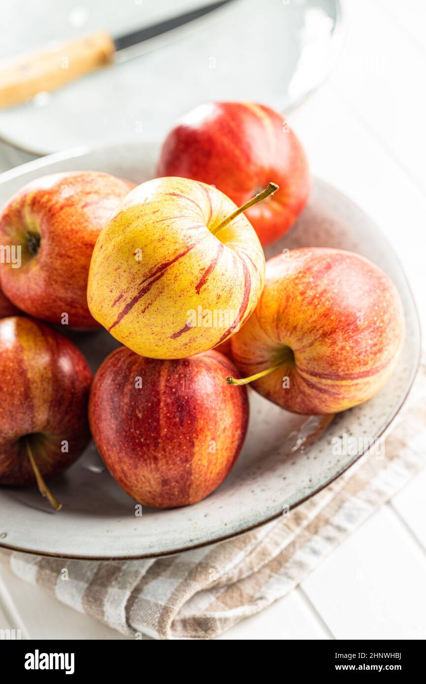 Fresh autumn apples on plate on white table. Stock Photo