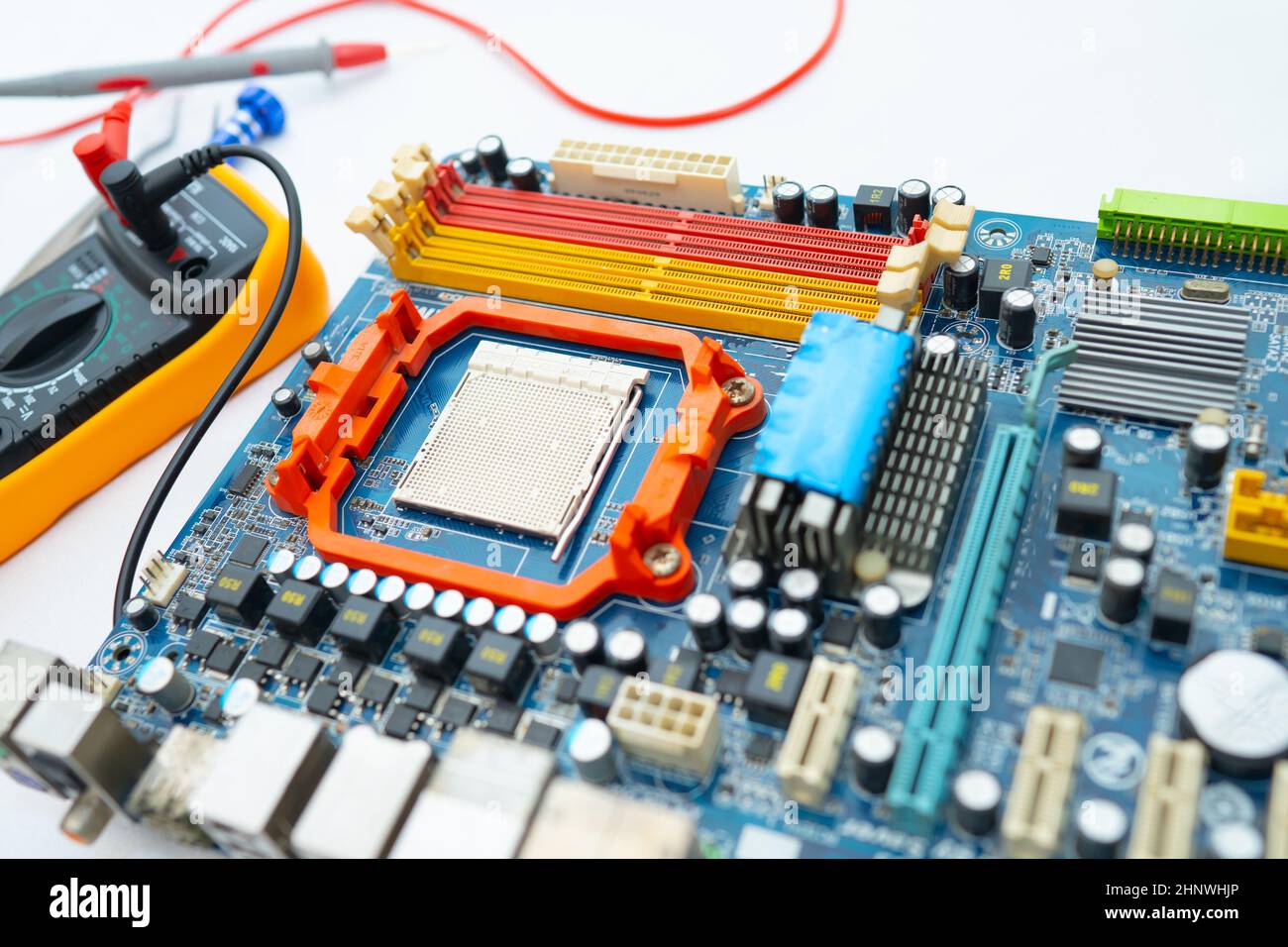 Multimeter with main board, maintenance, repairing and checking computer hardware concept. Stock Photo