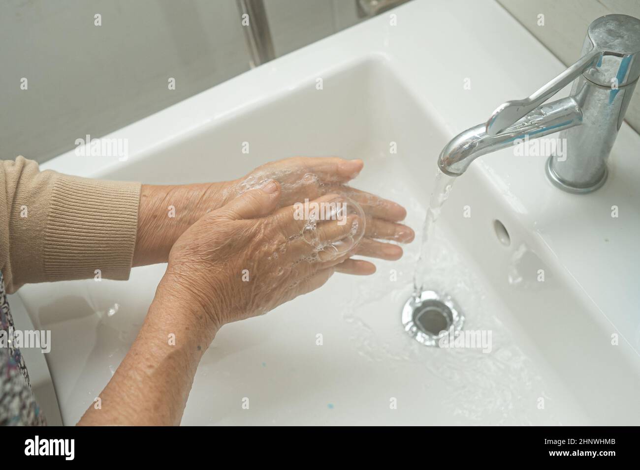 Asian senior or elderly old lady woman patient washing hand by soap and