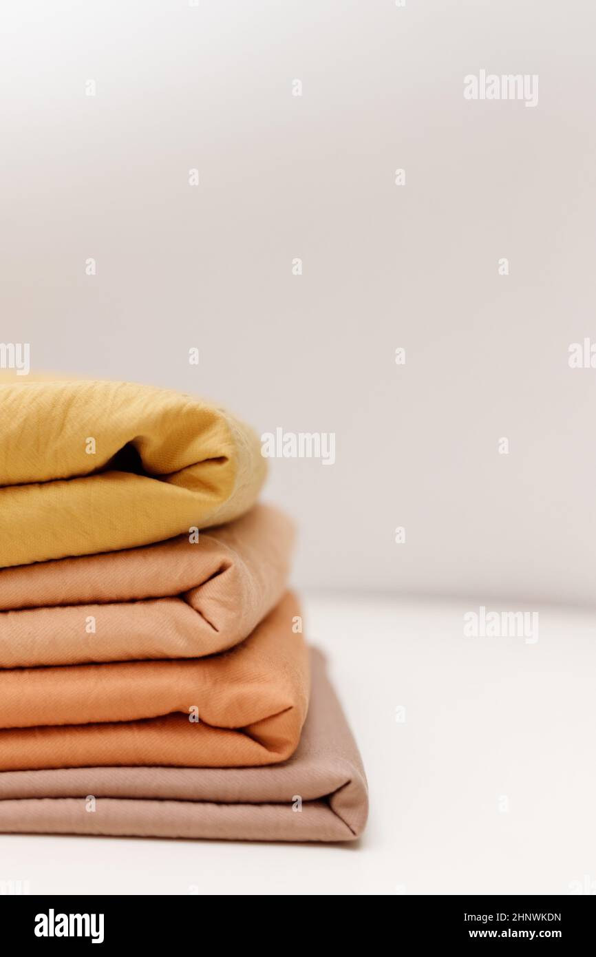 Stacks colorful cotton fabric, clothes. Copyspace Stock Photo