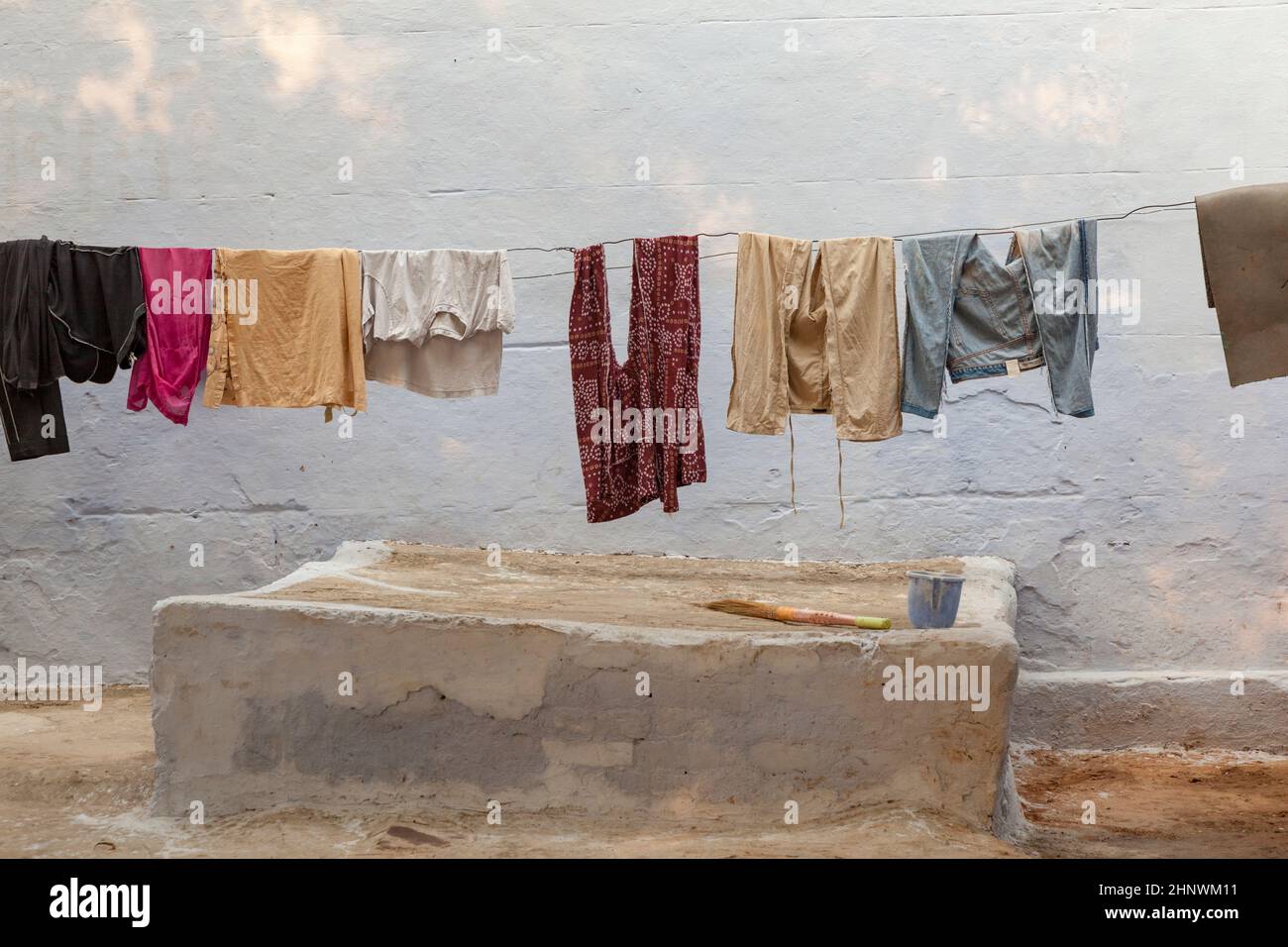 Clothes line with clothings in a typical indian house with colored wall Stock Photo