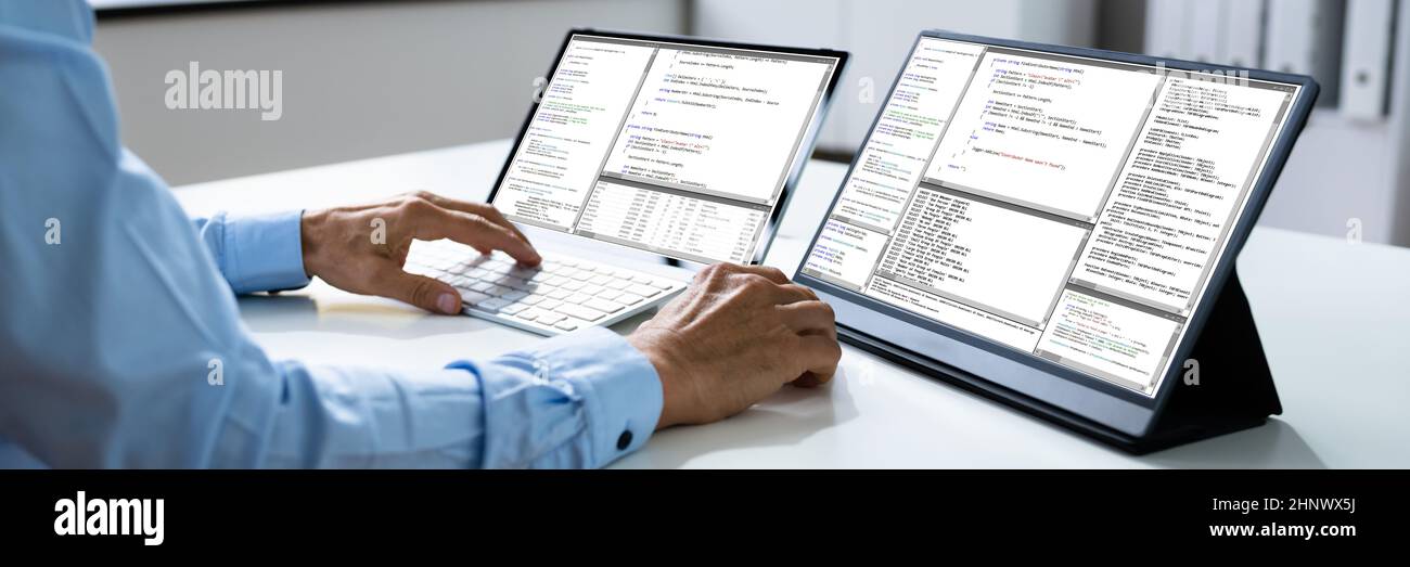 Computer Programmer Writing Program Code On Computer In Office Stock Photo