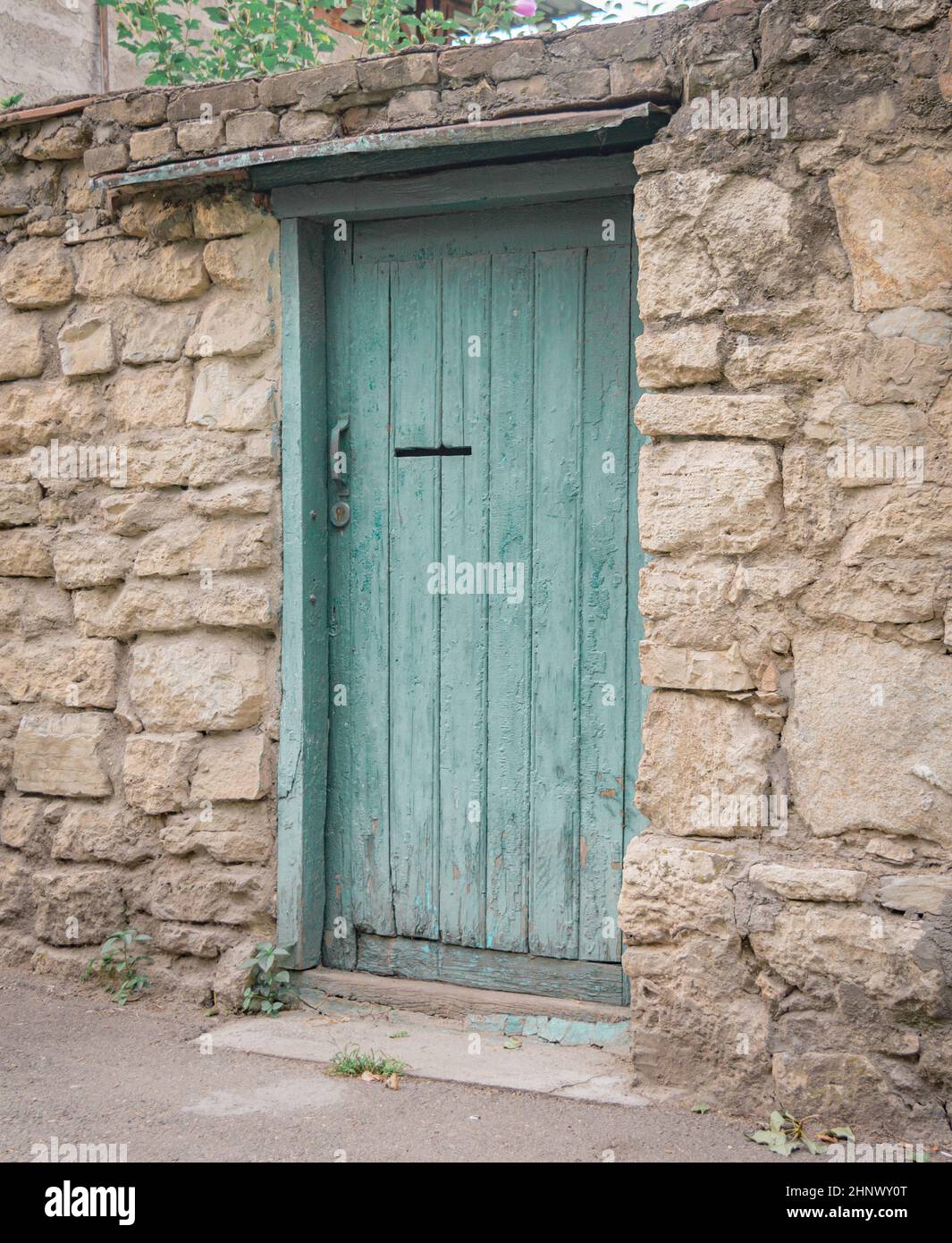 Green wooden door in the stone fence old-fashioned Stock Photo - Alamy