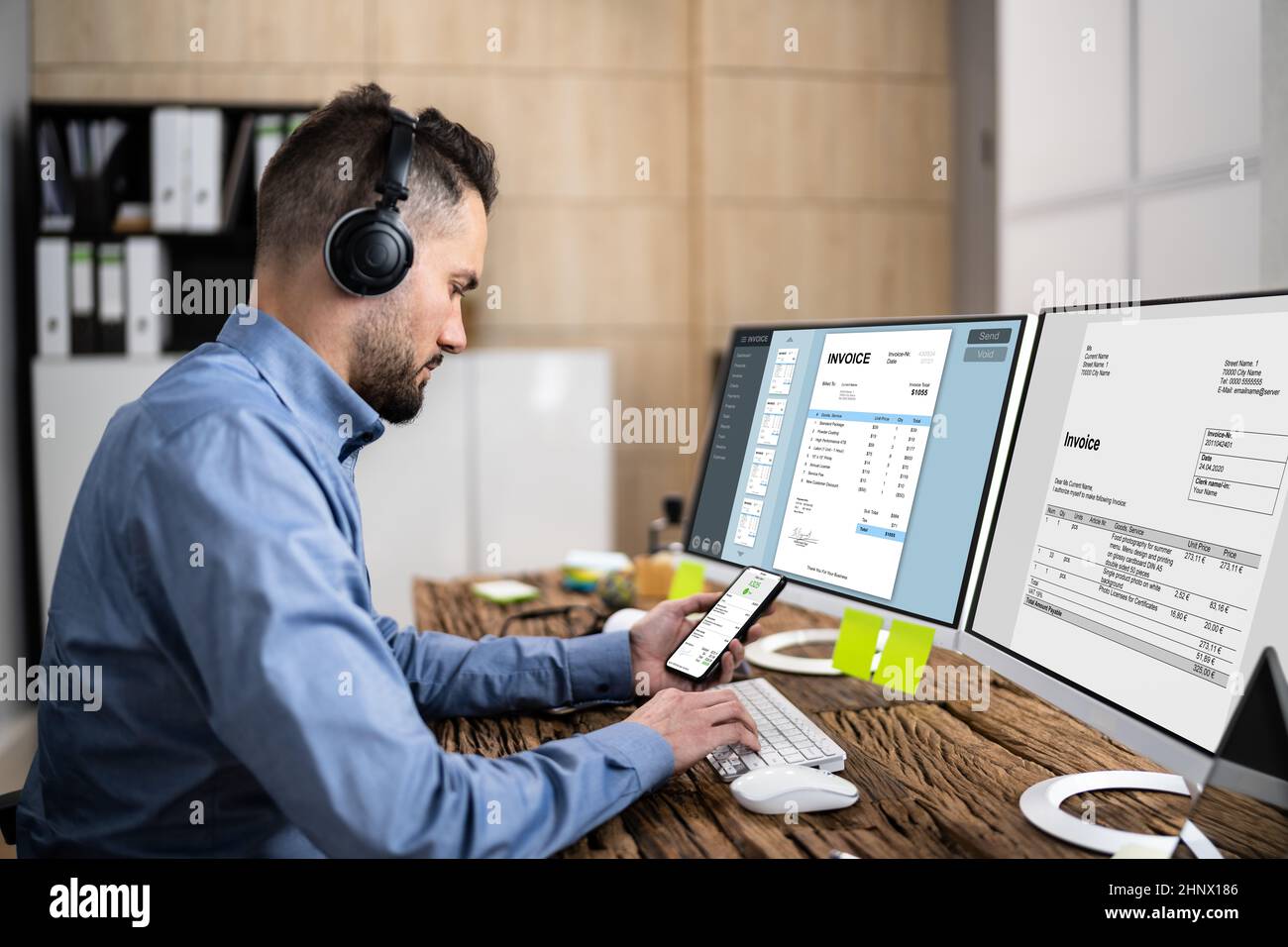Looking At Invoice And Spreadsheet On Computer At Work Stock Photo