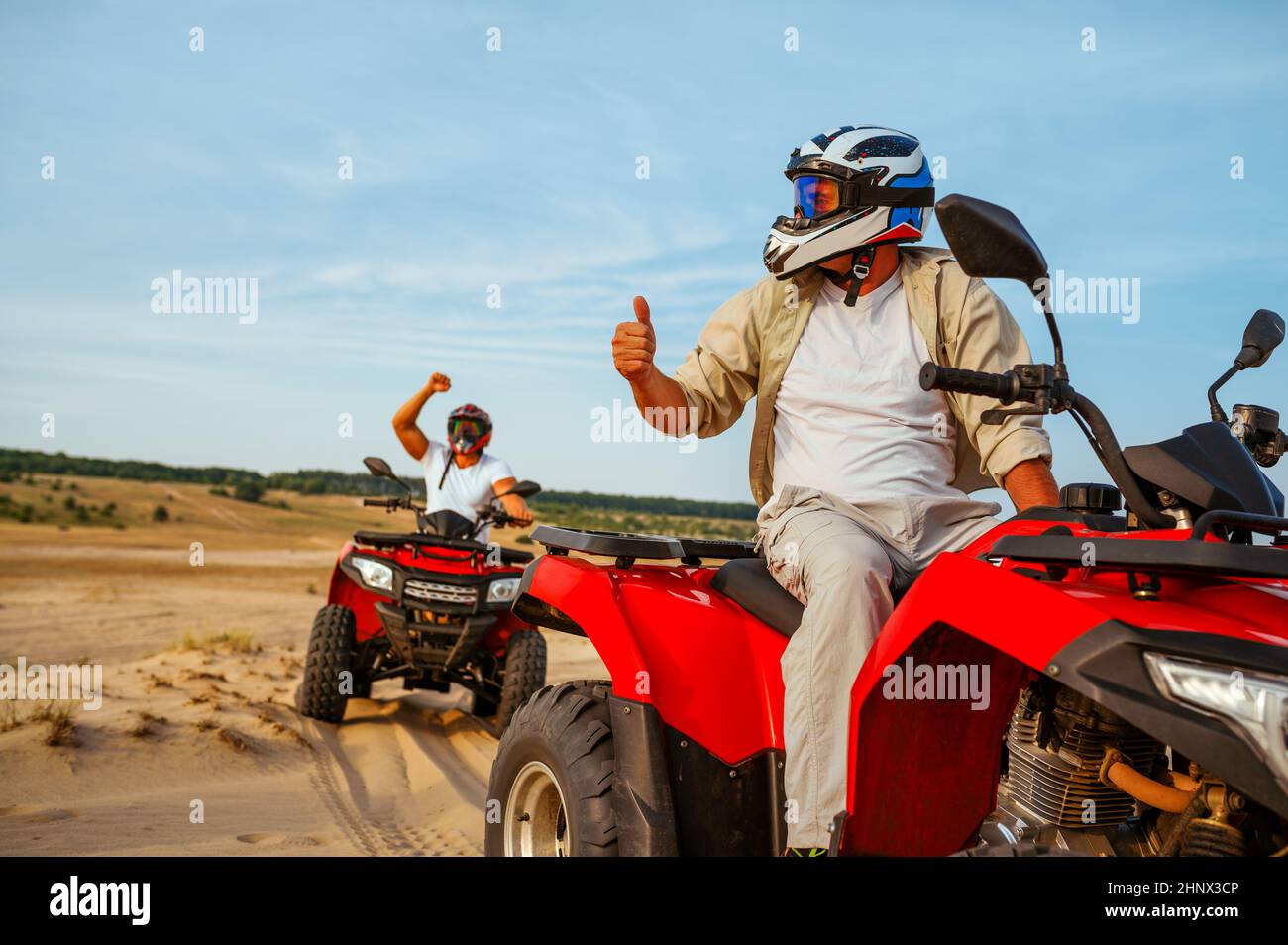 Men in helmets on atv, freedom riding in desert. Male persons on quad  bikes, sandy race, dune safari in hot sunny day, 4x4 extreme adventure, quad-bik  Stock Photo - Alamy