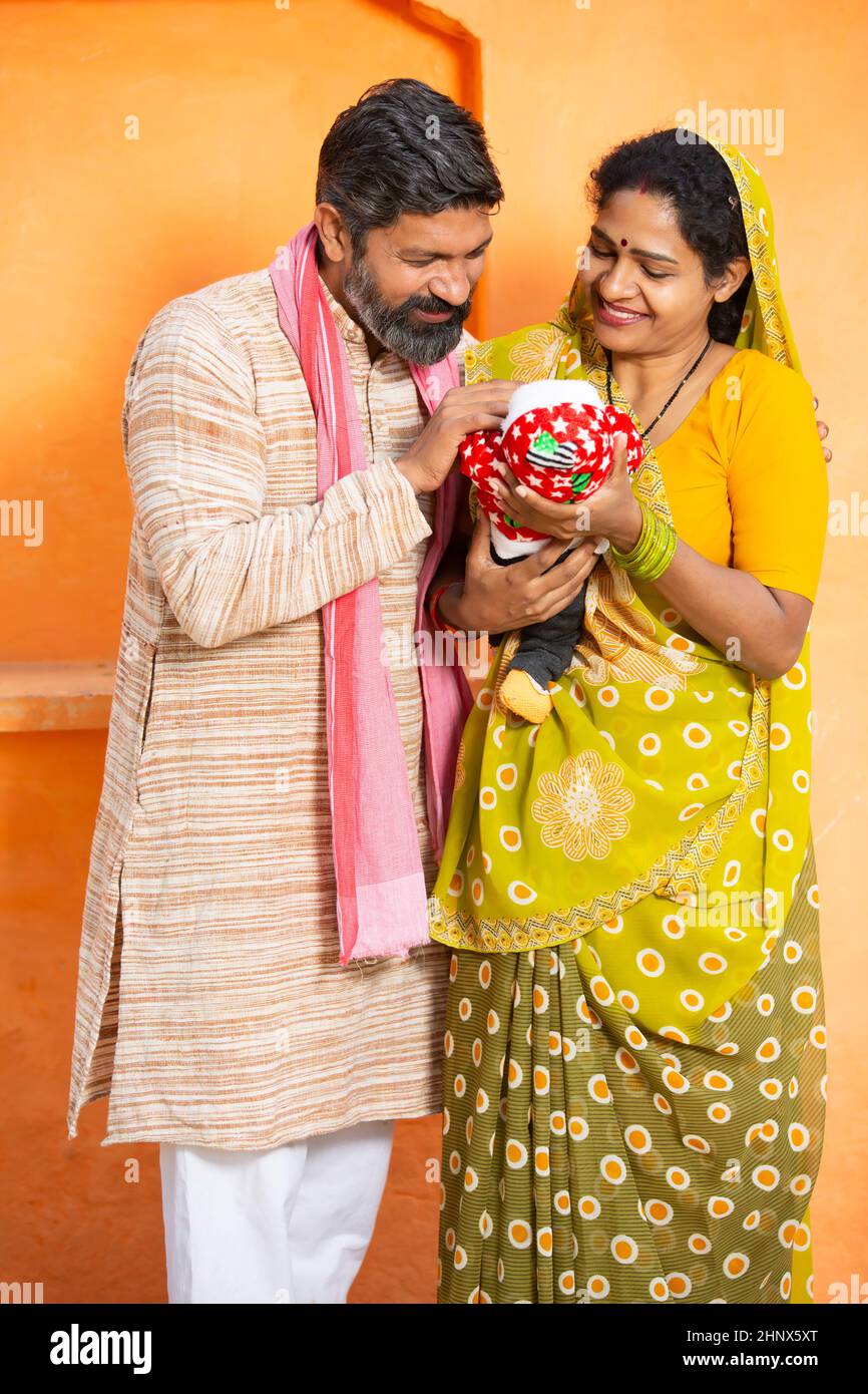 Portrait of happy rural Indian parents with newborn baby, couple father ...