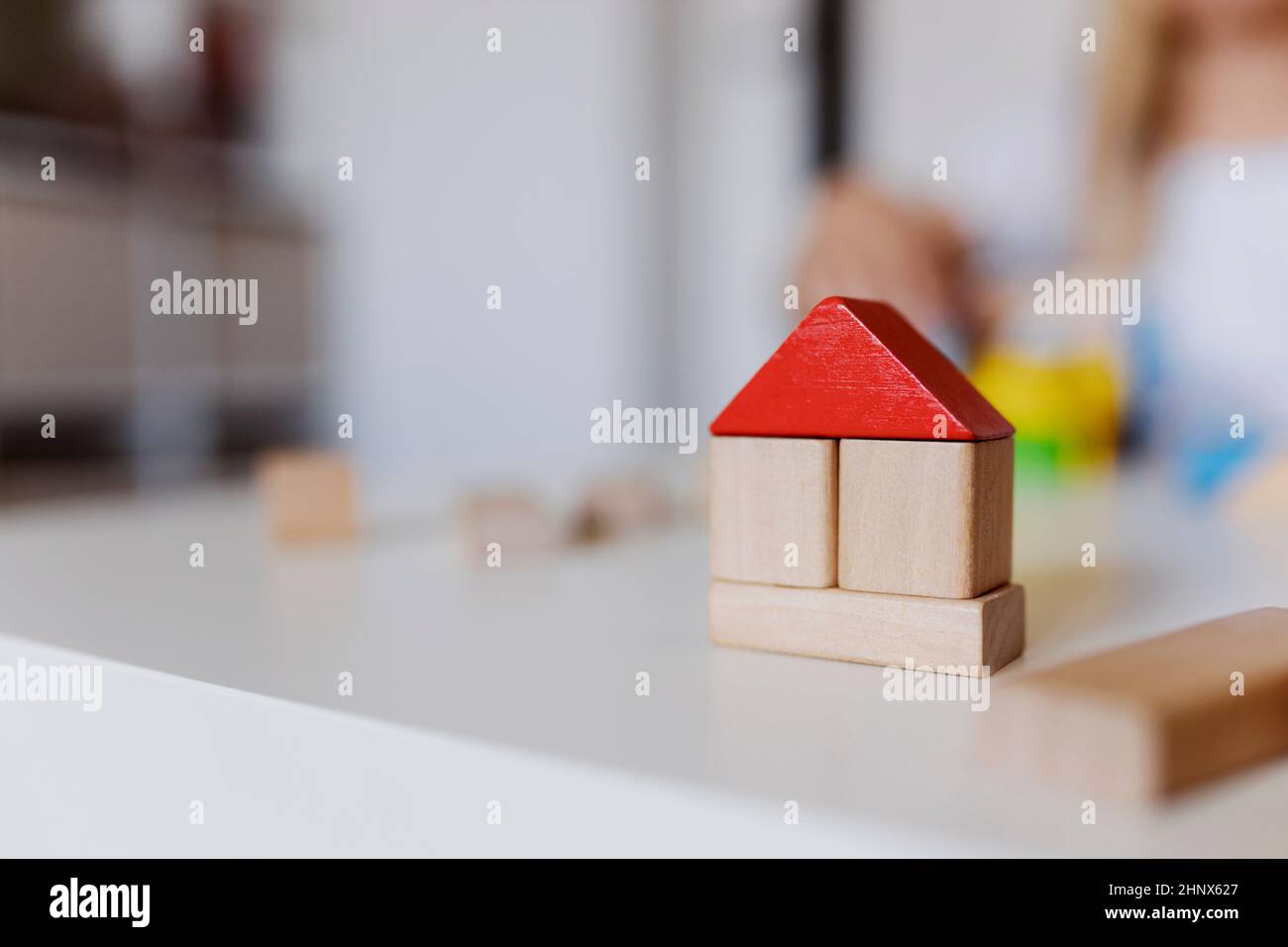 Child girl playing with colorful wooden toy building blocks. Little kid building tower or house