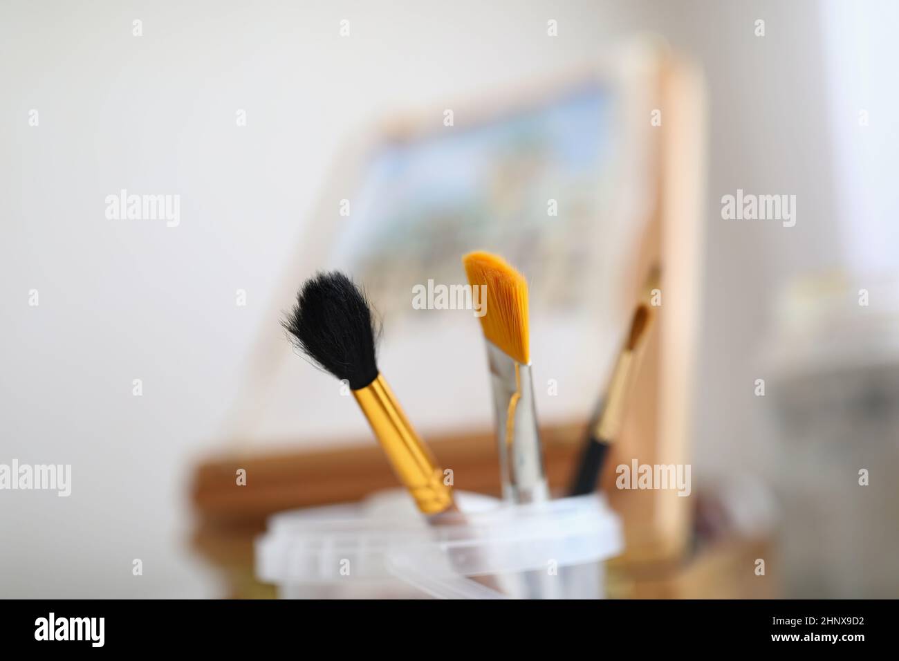 Painting brushes and easel stand in the room Stock Photo Alamy