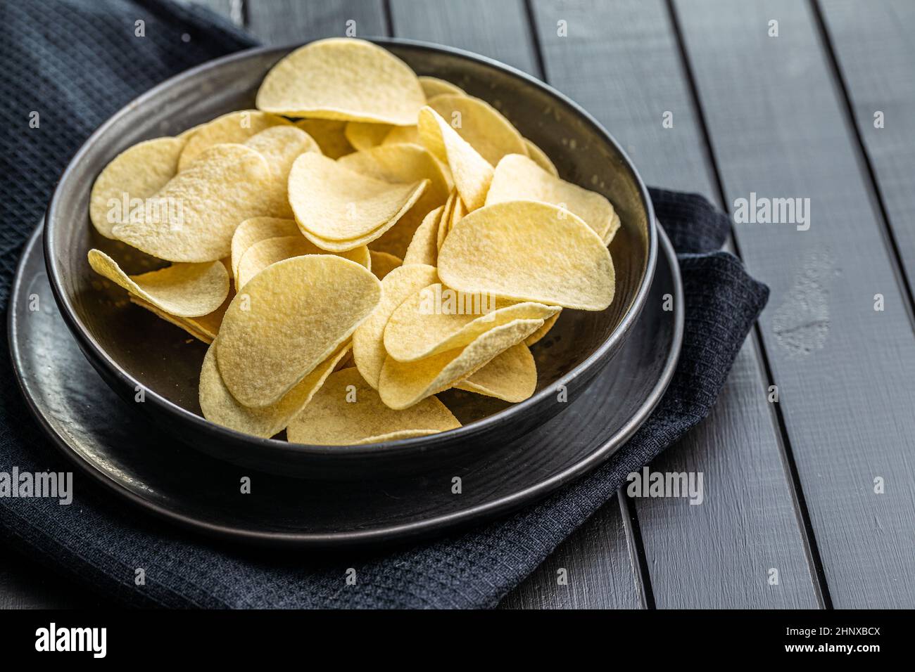 Crunchy potato chips. Potato crisps on black table Stock Photo Alamy