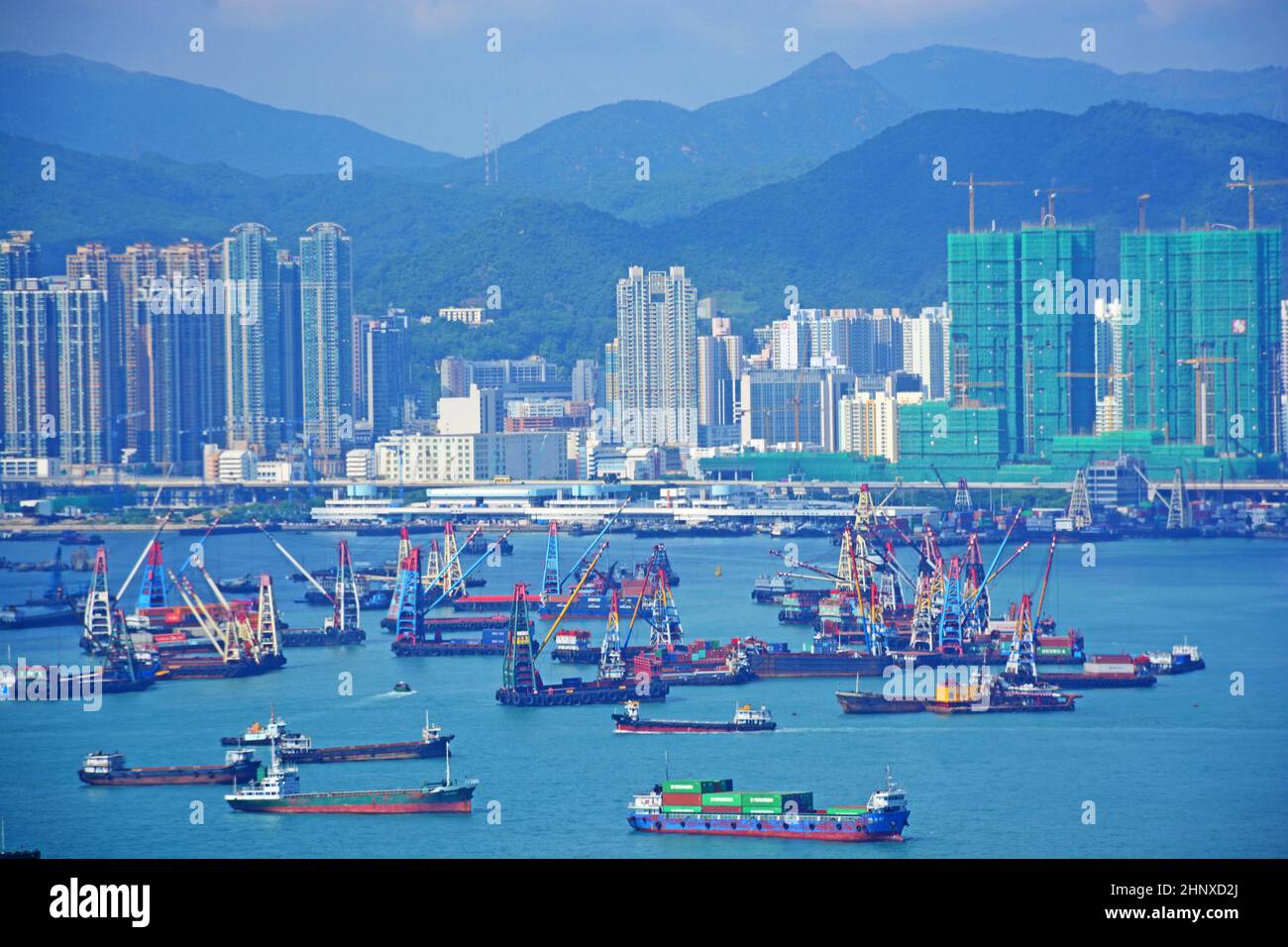 Cargo ships in the bay of Hong Kong await loading and unloading of cargo from their hulls Stock Photo