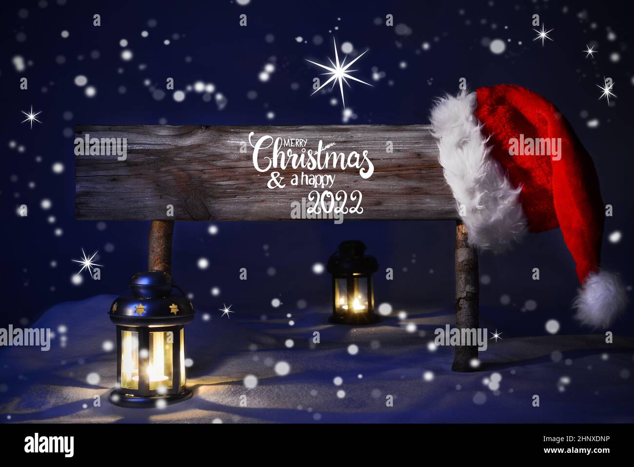 A Merry Christmas Peaceful 2022 Sign With English Calligraphy Merry Christmas And Happy 2022. Peaceful  Christmas Night With Snow And Lamp Stock Photo - Alamy