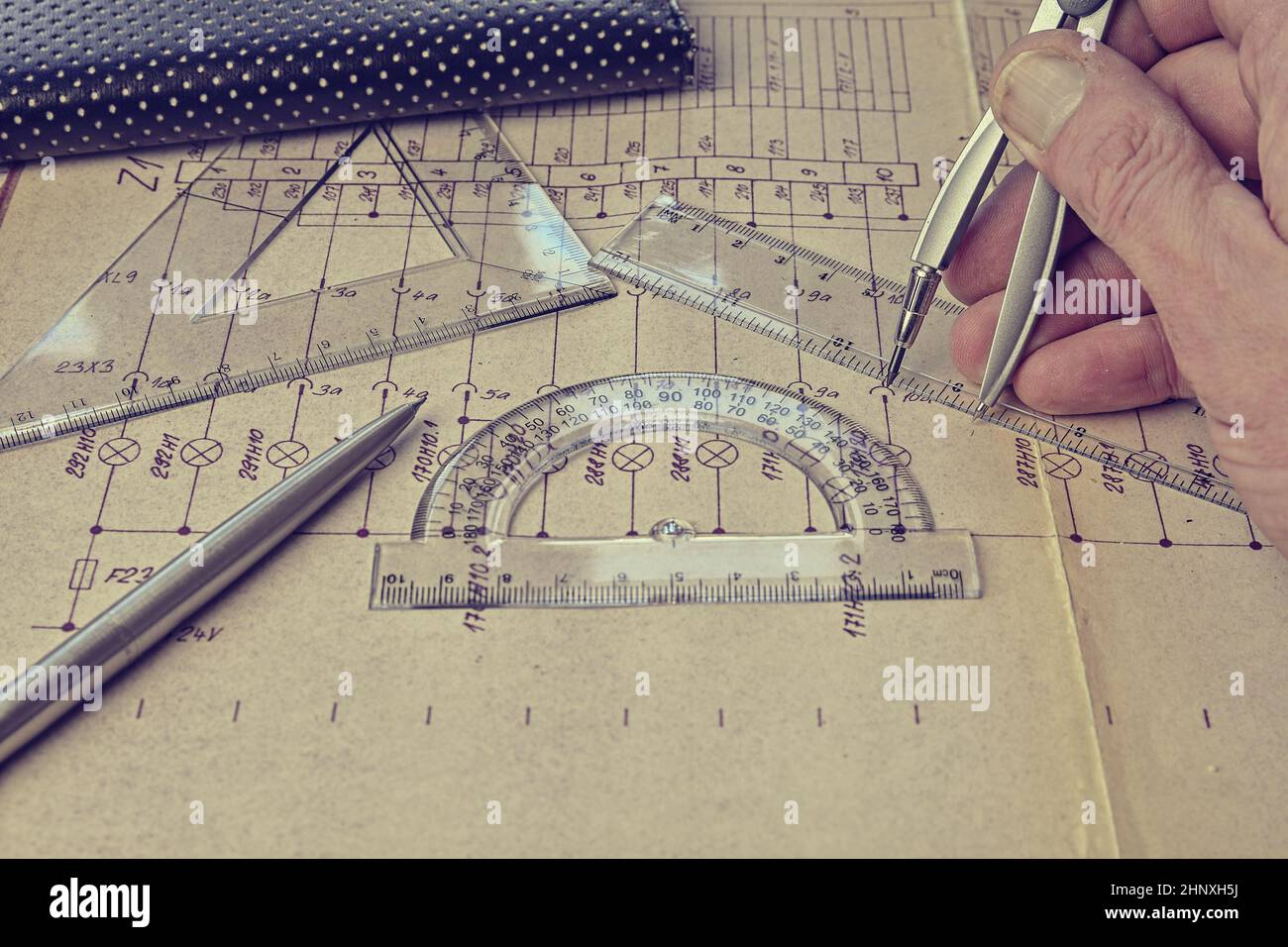 Electrical engineer workplace - electrotechnical project, rulers, and divider compass. Construction and electrotechnology concept. Engineering tools. Stock Photo