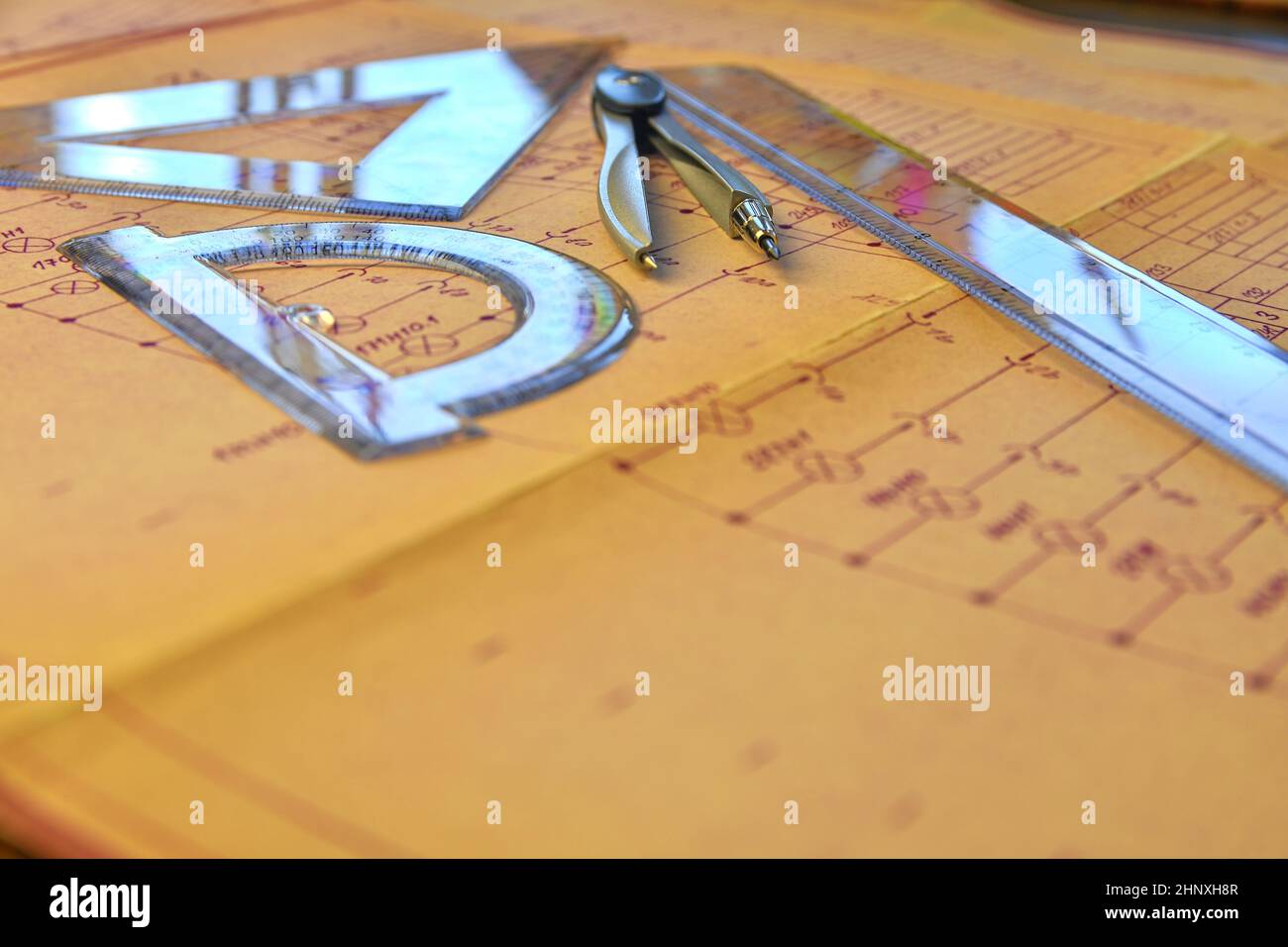 Electrical engineer workplace - electrotechnical project, rulers, and divider compass. Construction and electrotechnology concept. Engineering tools. Stock Photo