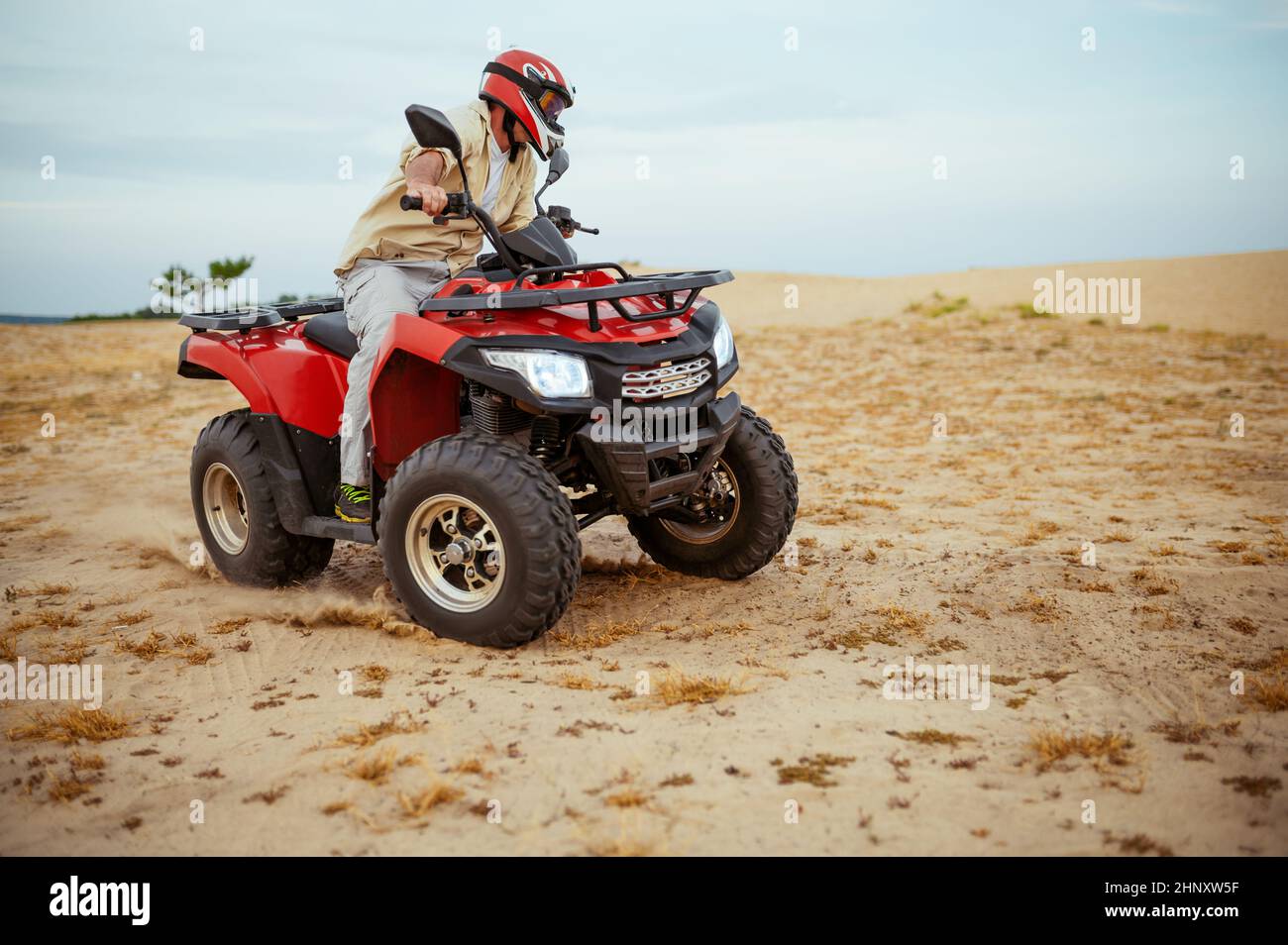 An atv rider racing in desert, downhill riding in desert sands, action ...