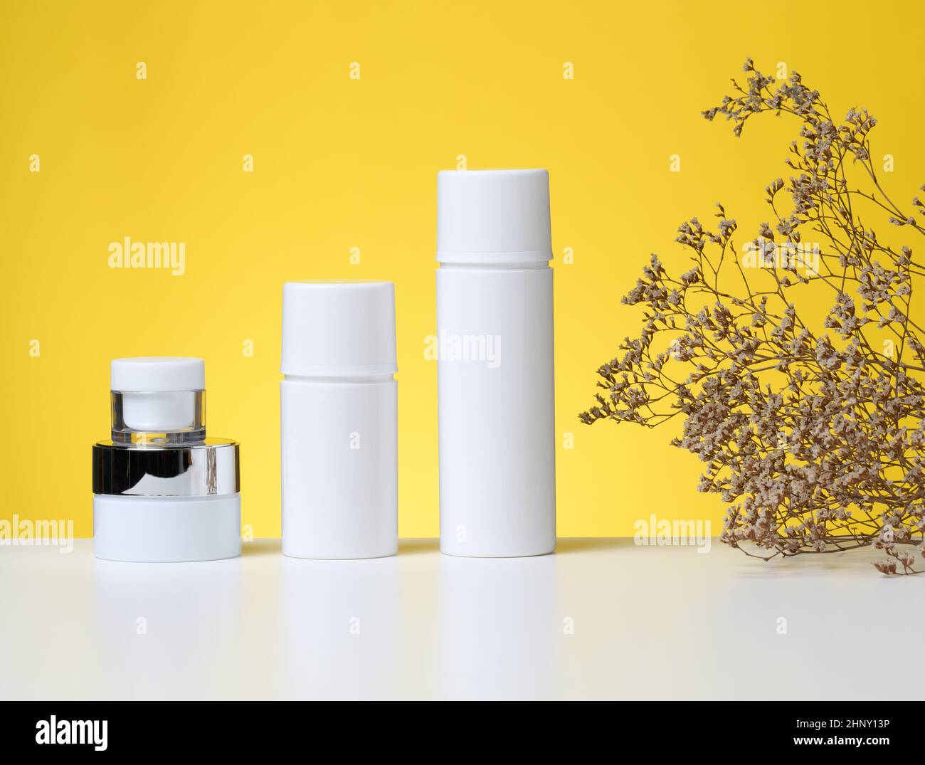 empty white plastic tubes and jars for cosmetics. Packaging for cream
