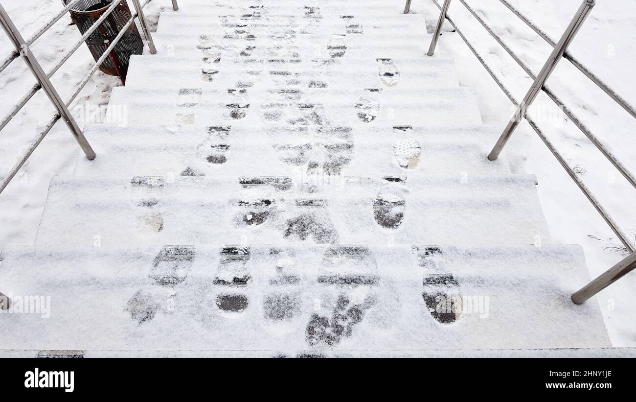 stair railings and snow. Slippery steps, ice covered with footprints