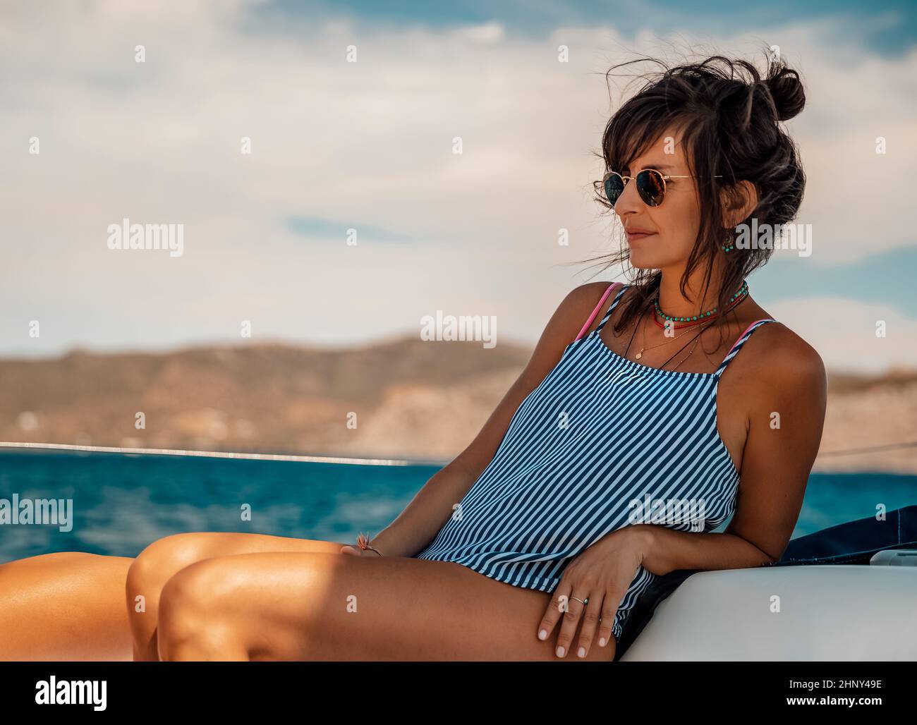Nice Girl Tanning on the Sailboat. Luxury Summer Trip to Greece. Recreation on Water Transport. Enjoying Vacation on the Yacht. Stock Photo
