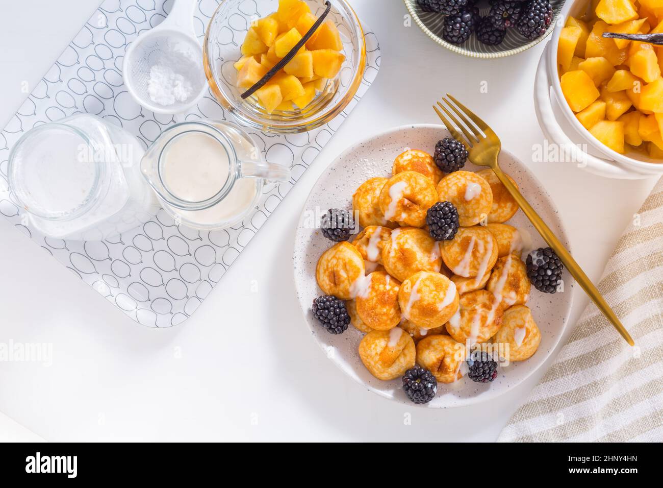 Dutch mini pancakes called poffertjes with blackberries and apple compot Stock Photo