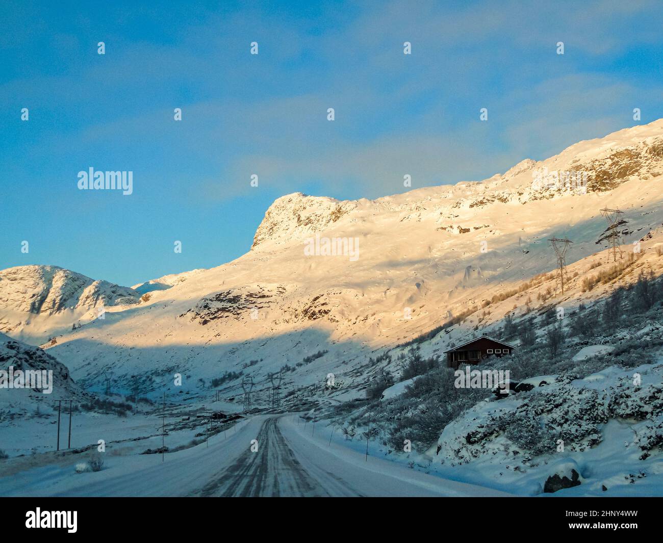 Driving at golden sunrise through mountains and village in Norway
