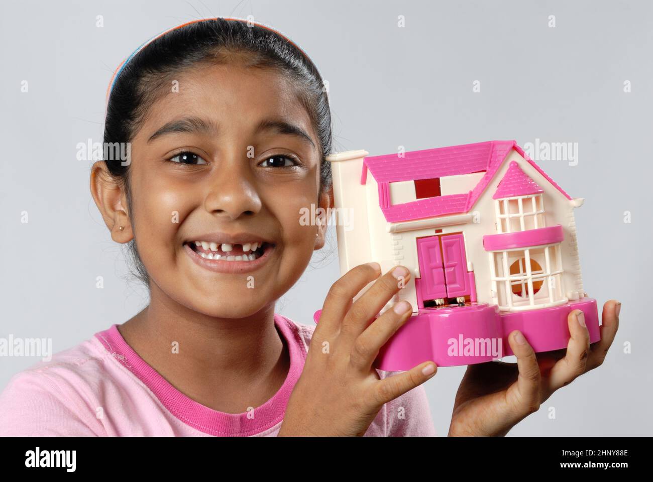 Mumbai; Maharashtra; India; Asia; May. 05; 2008 - Indian cute little girl dreaming about a new house or home concept Stock Photo
