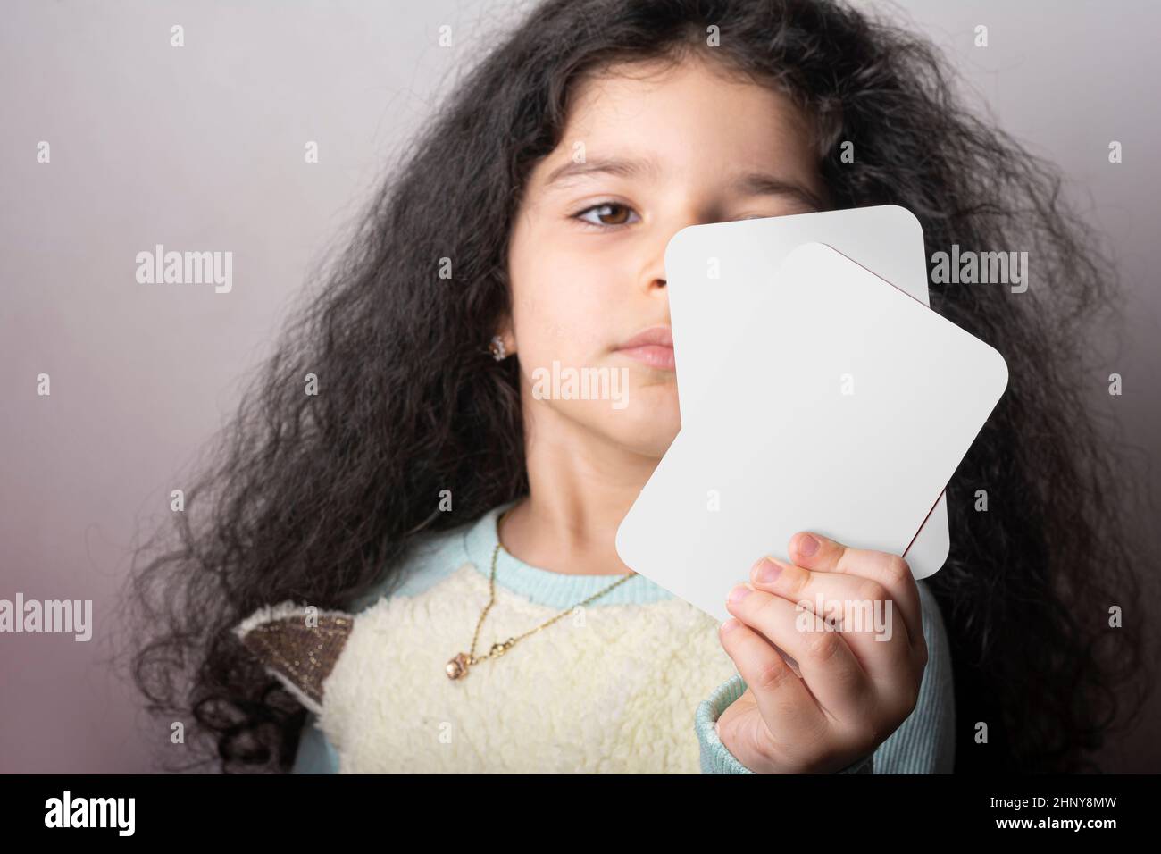Little girl portrait holding two flash card in hand, preschool learning