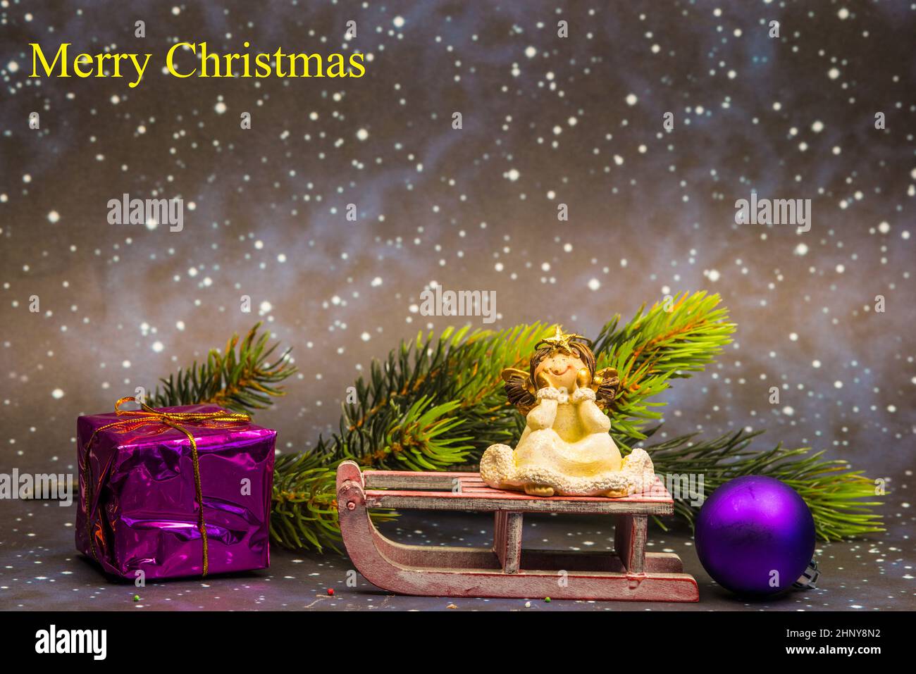 angel on sledge with night sky background and Merry Christmas text