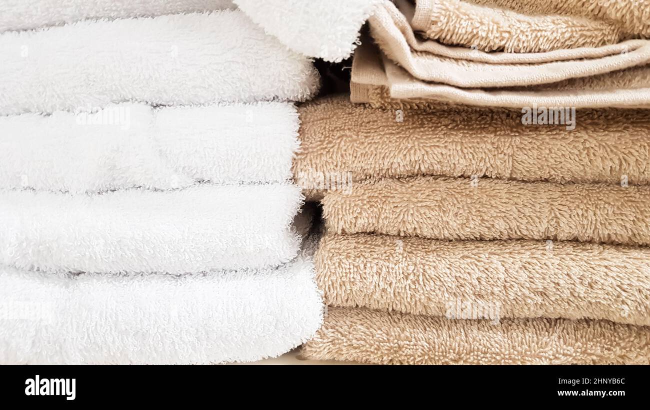 Stacks of fluffy bath towels of various colors in a store window. Terry