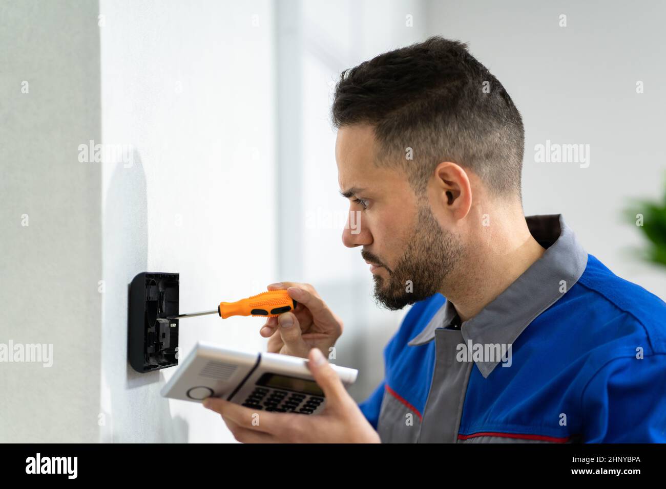 Technician Installing Security Access Alarm System Control Stock Photo
