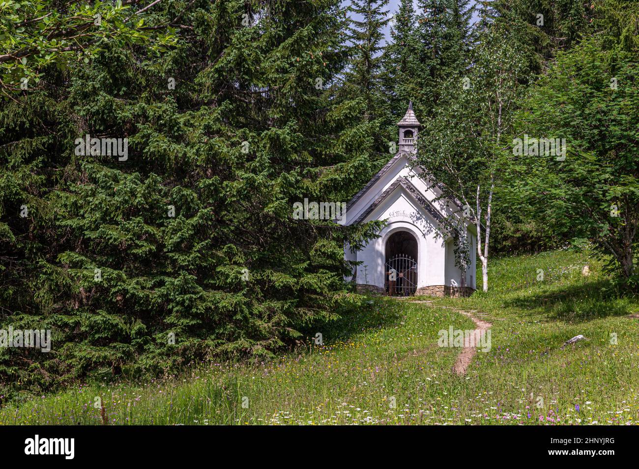 small white church immersed in the green of the alpine woods Stock ...