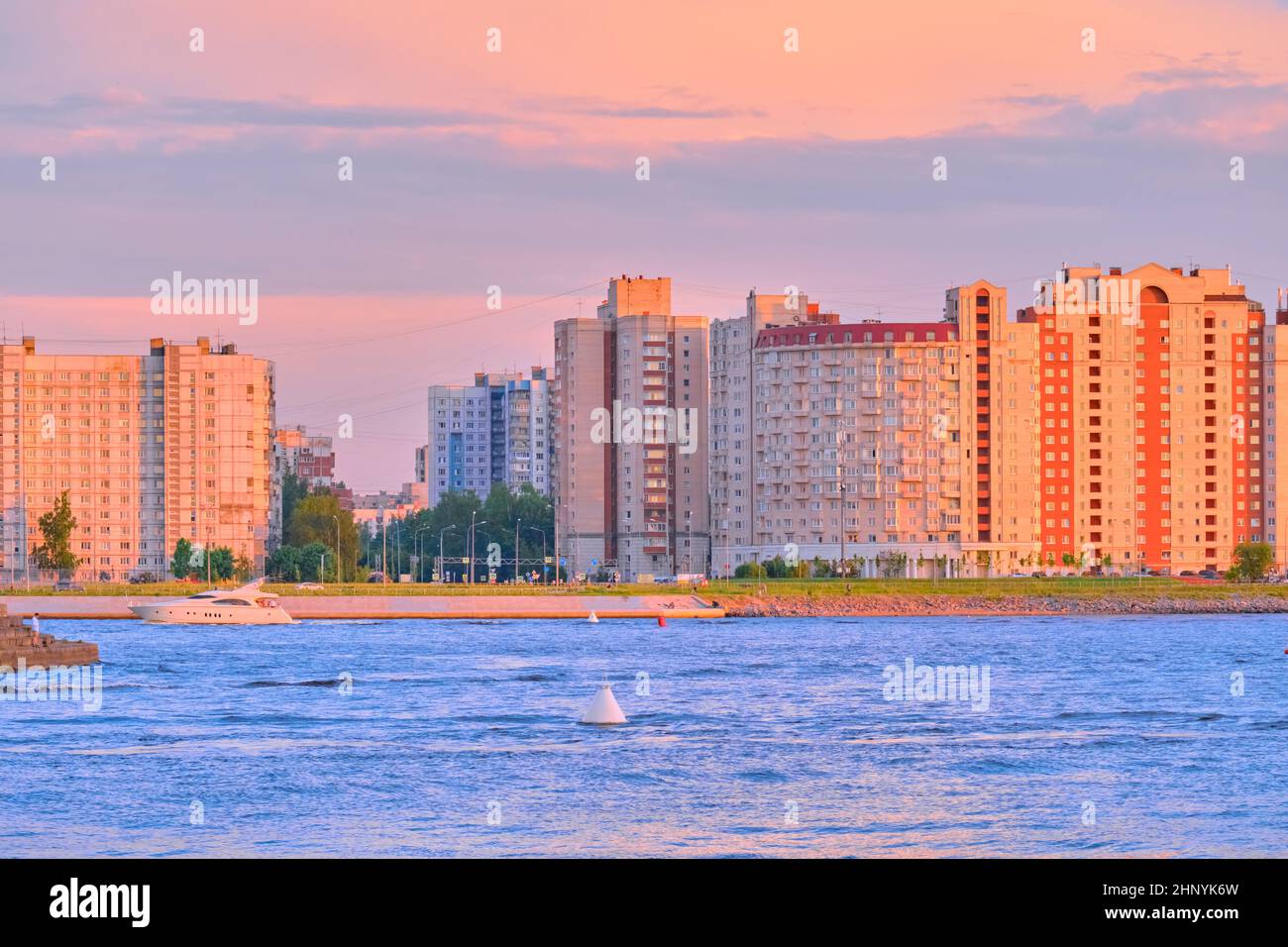 Saint-Petersburg, Russia - Jun 09, 2021: New houses in the Nevsky Bay area at sunset. Boats and boats move on the water Stock Photo