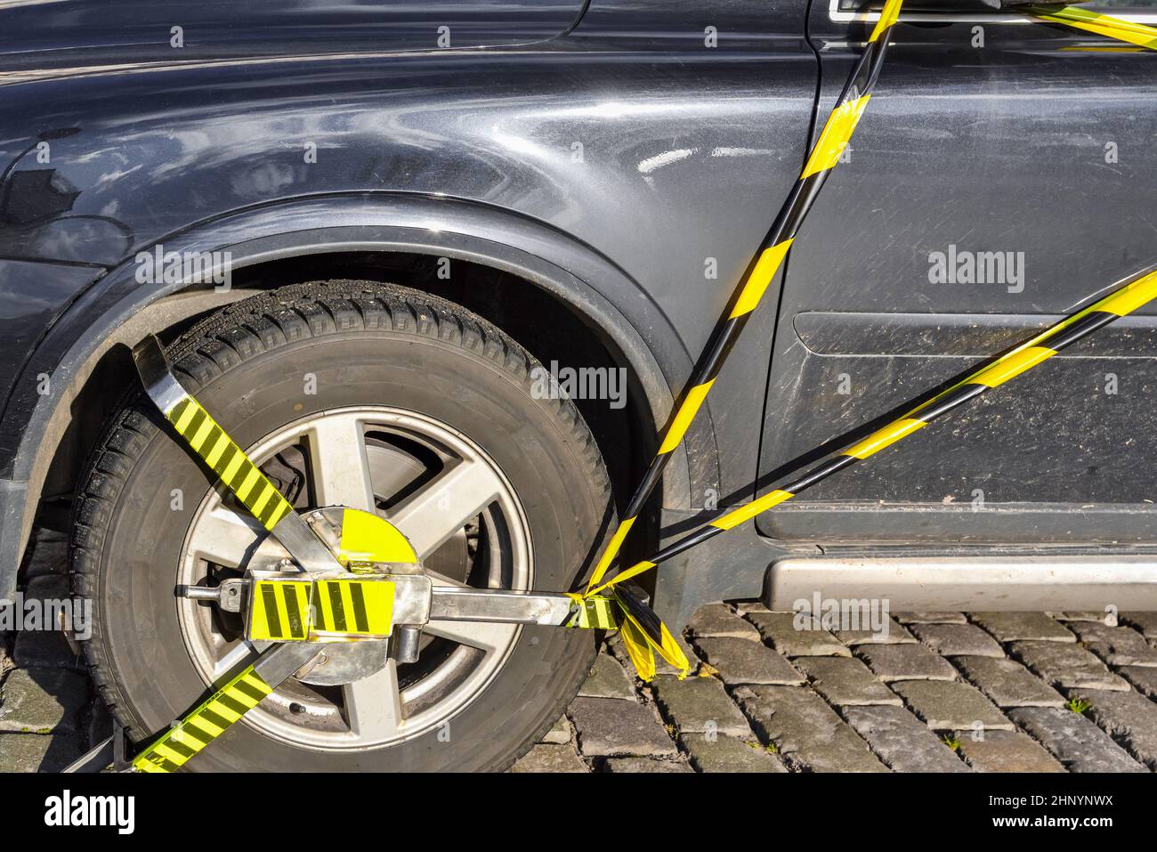 Car wheel is locked and booted due illegal parking violation. Police