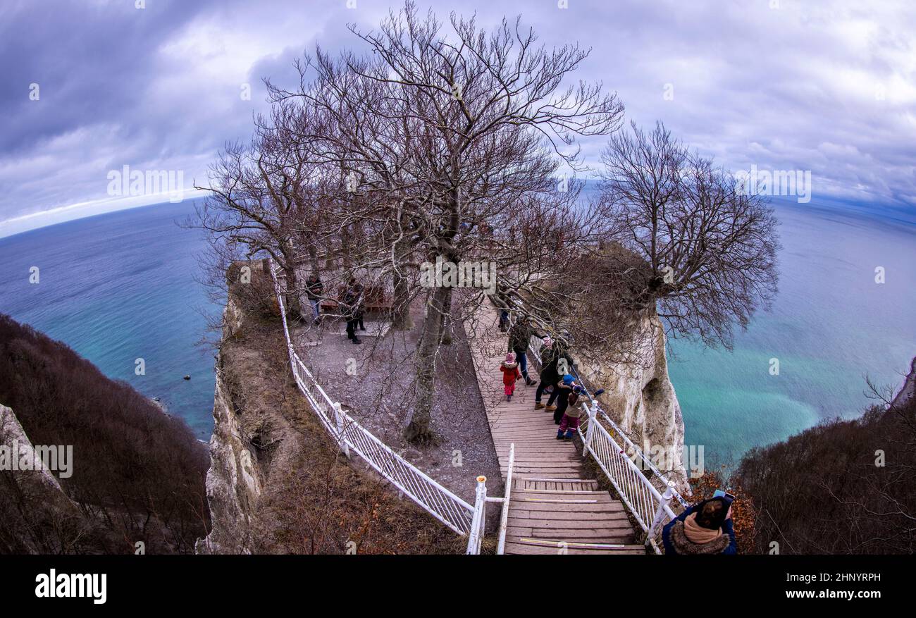 15 February 2022, Mecklenburg-Western Pomerania, Sassnitz: Visitors walk up a staircase to the Königsstuhl viewing platform on the chalk coast of the island of Rügen, which is only open until the end of April 2022. (Exception with extreme wide-angle lens) Behind it, parts of the chalk coast and the beech forest can be seen. To protect the 118 meter high chalk cliff on the Baltic Sea, visitors will in future be able to admire the view from an oval 185 meter long bridge circuit above the cliff. The new steel structure is to have a load capacity of 163 tons and be able to accommodate up to 1,100 Stock Photo