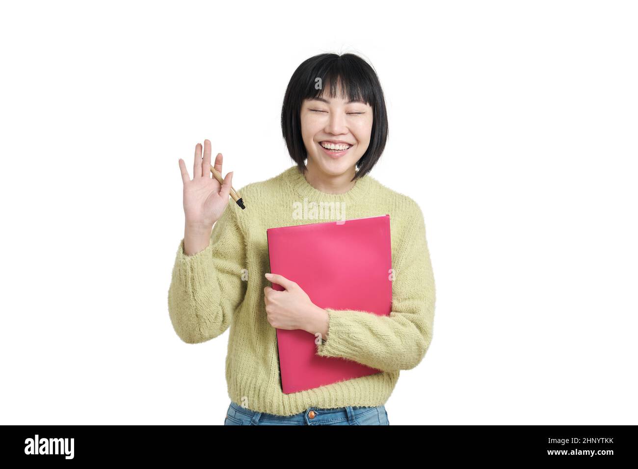Young asian student smiling and waving hand with her eyes closed, isolated. Stock Photo