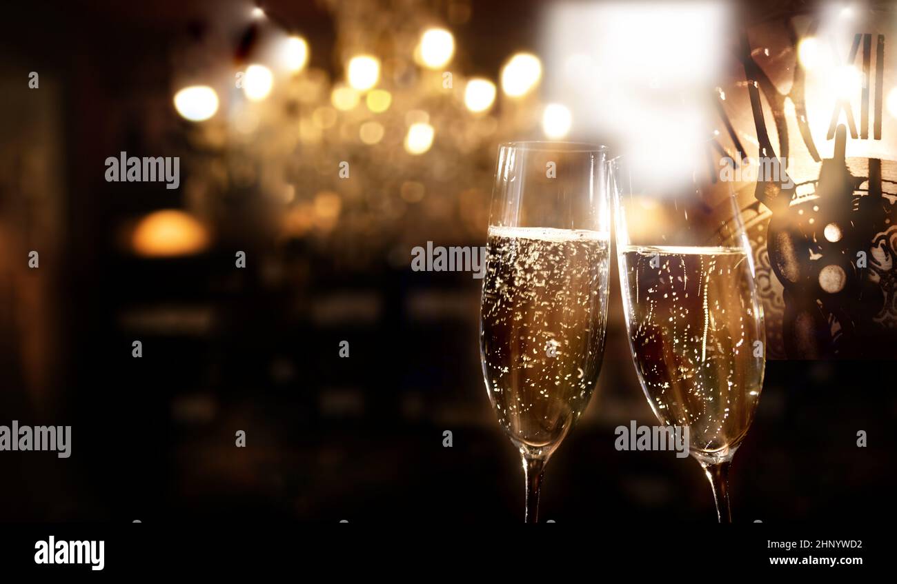 New year celebration with sparkeling champagne. Festive new year's eve background with golden bokeh and space for text. Stock Photo