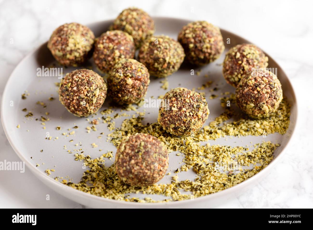 Date and nuts energy balls rolled in pumpkin seeds powder Stock Photo