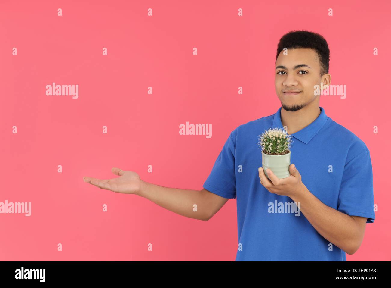 Young man with cactus on pink background Stock Photo