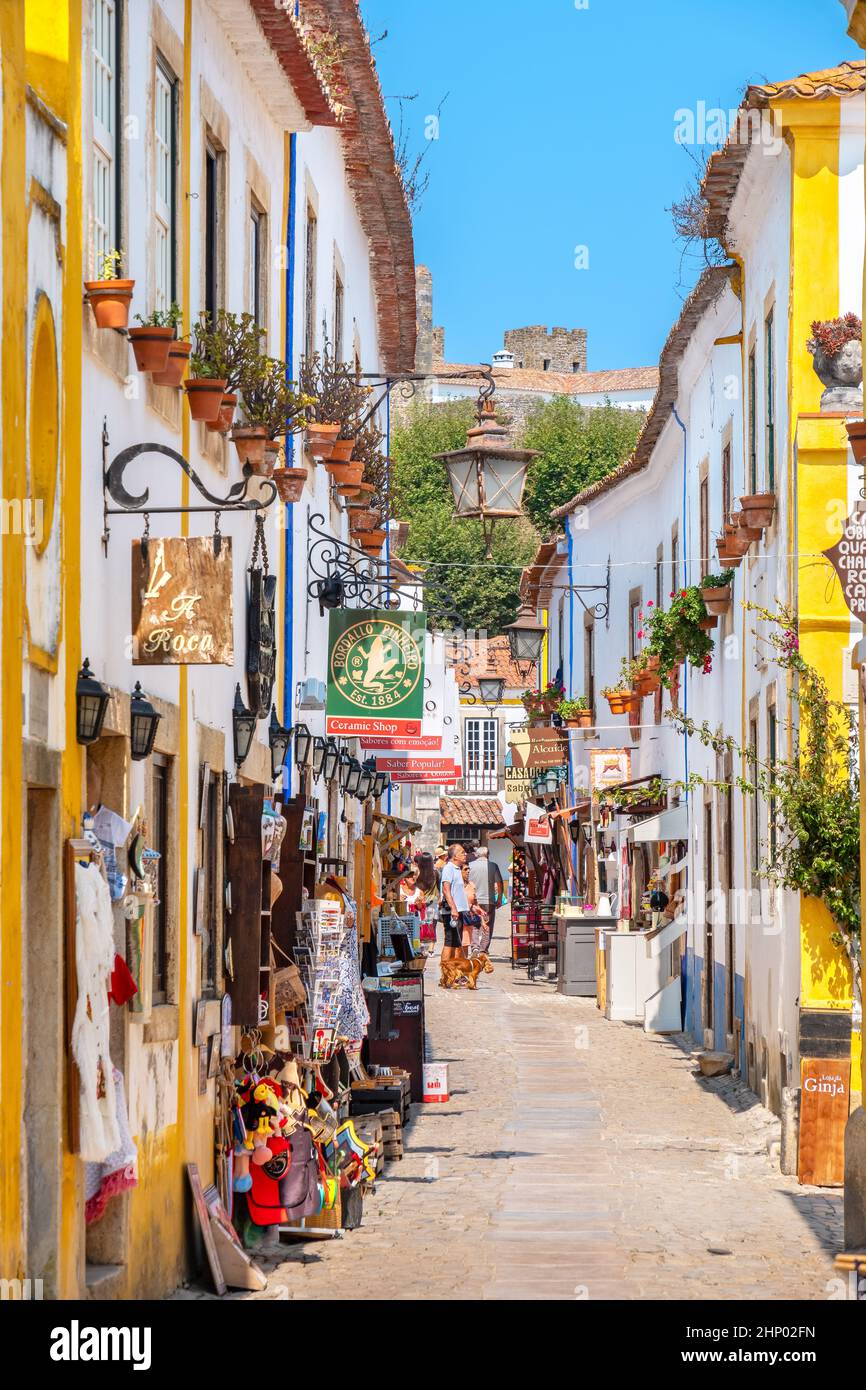 Tourist walking on cobbled street of medieval town of Obidos. Portugal Stock Photo